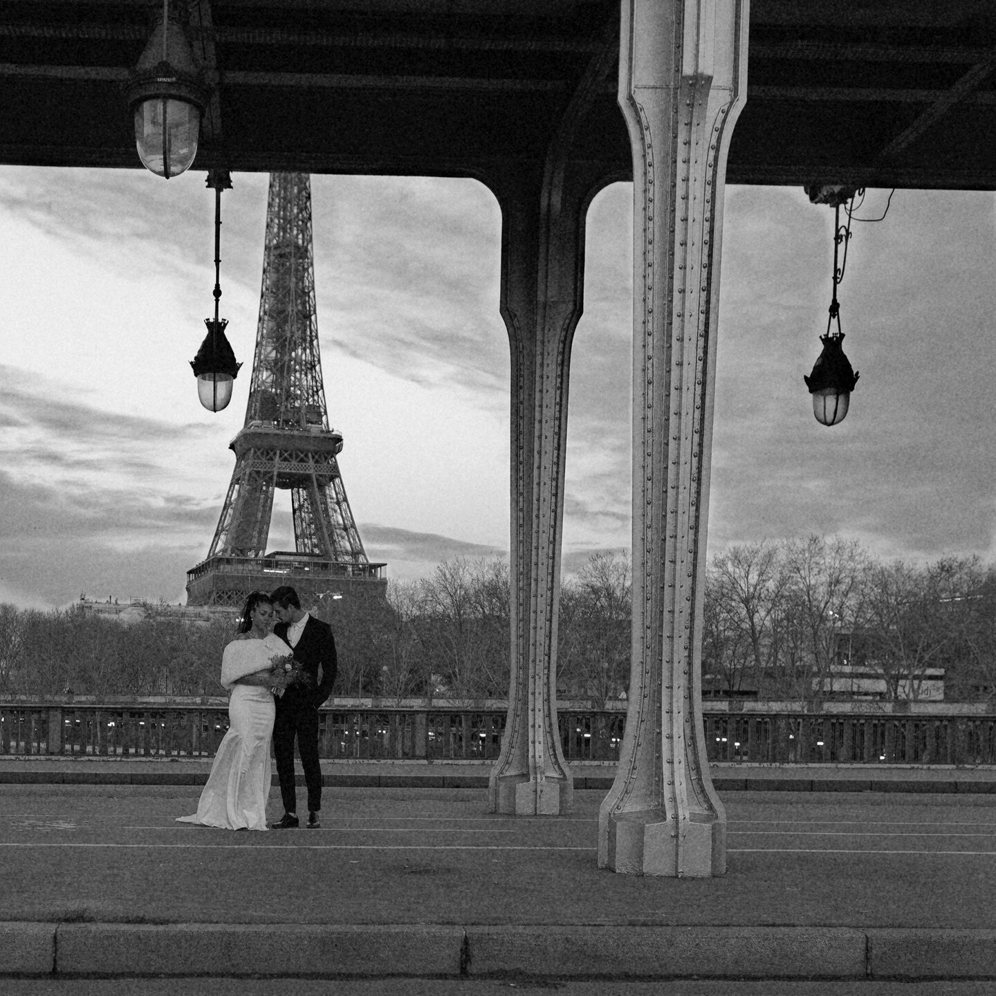 &quot;Love is in the air as our beautiful bride and groom share a moment of contemplation beneath the picturesque Pont de Bir-Hakeim in Paris. This iconic bridge, a favorite among brides from around the world, sets the perfect scene for their special