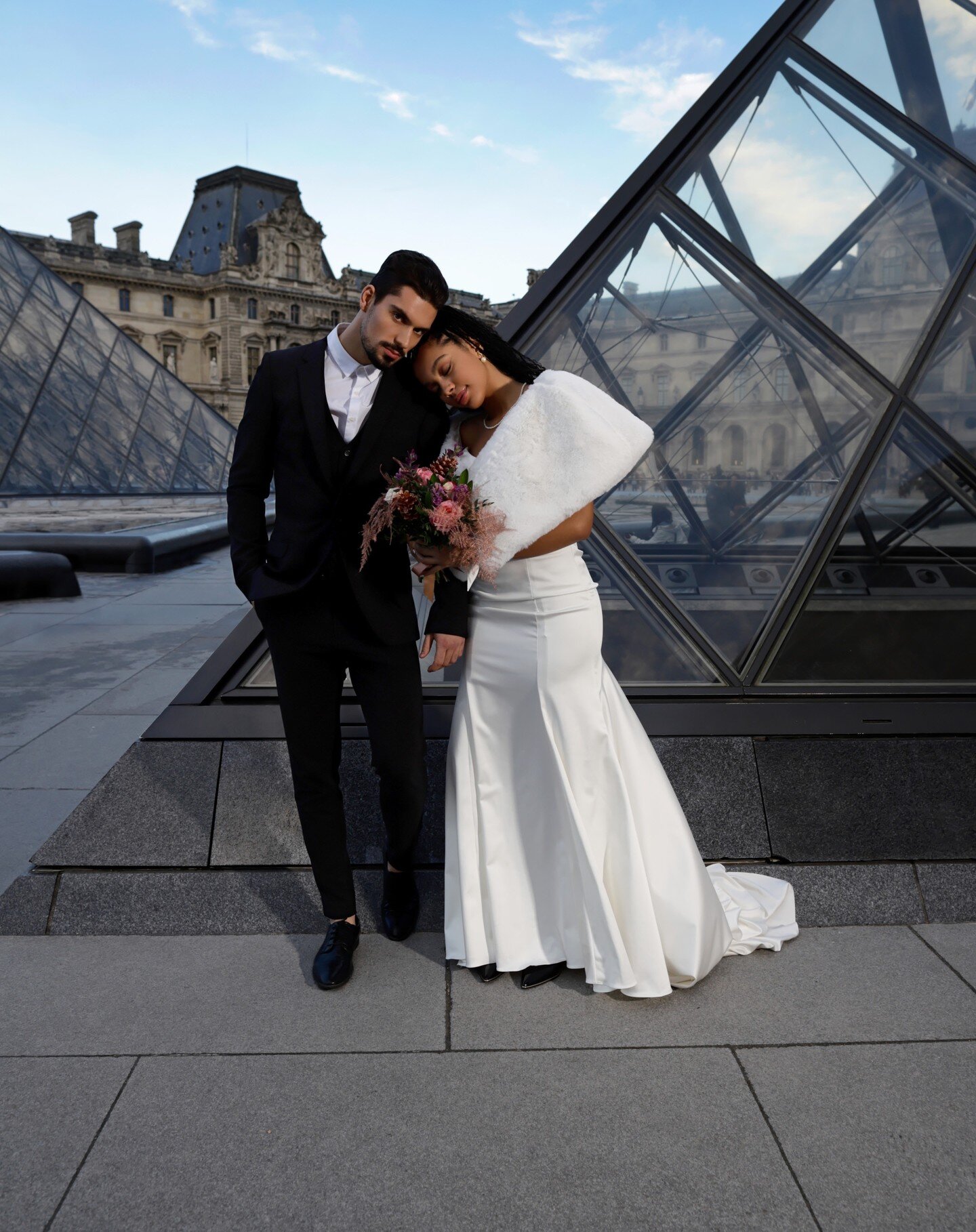 &quot;Elegance and romance come to life in this stunning bridal portrait at the Louvre. Our couple shares a timeless look of love in front of the iconic Pyramide du Louvre. Are you ready to capture the magic of your dream wedding in the City of Love?