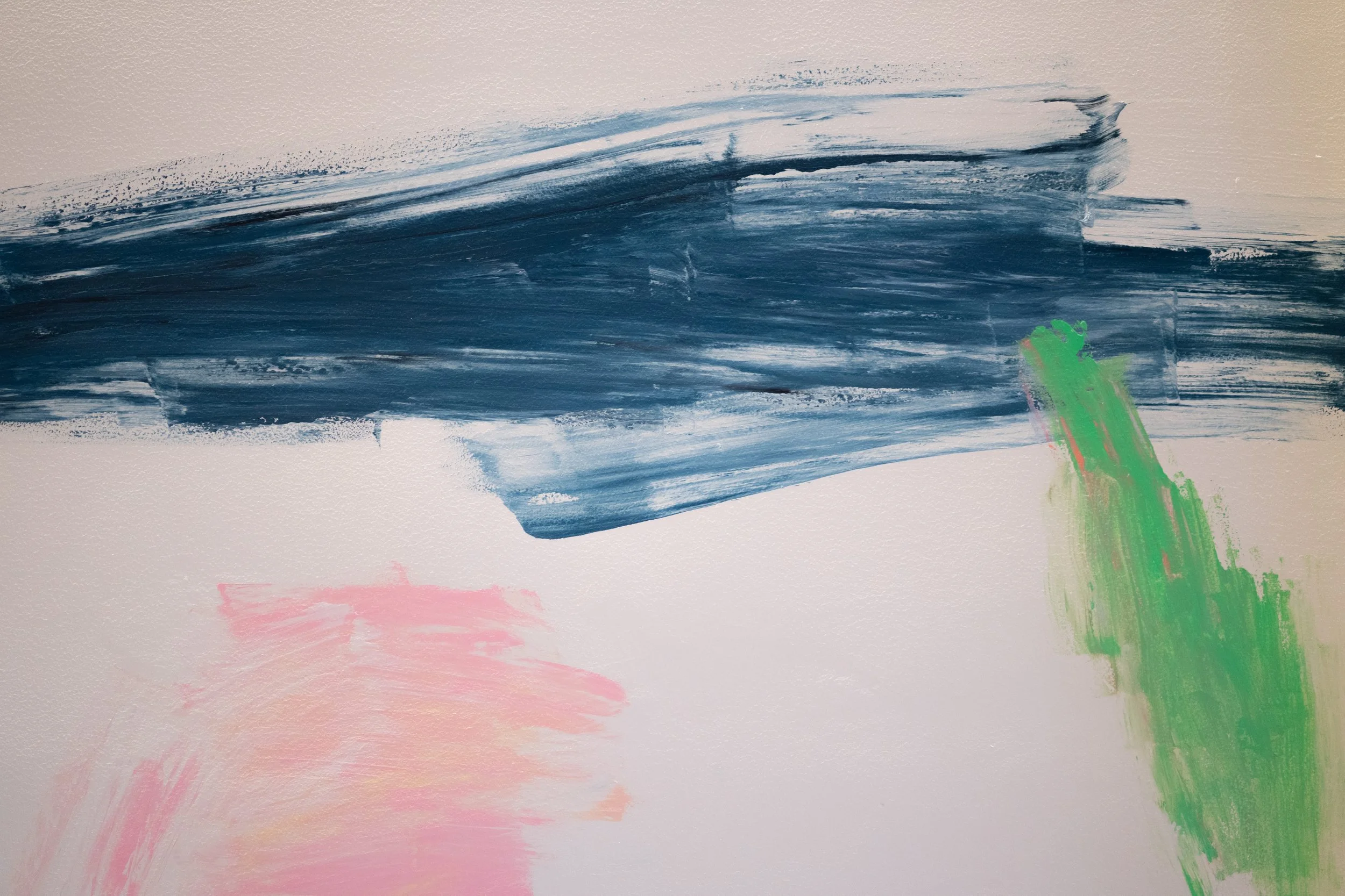 Pinceladas abstractas en colores azul, rosa y verde sobre fondo blanco.