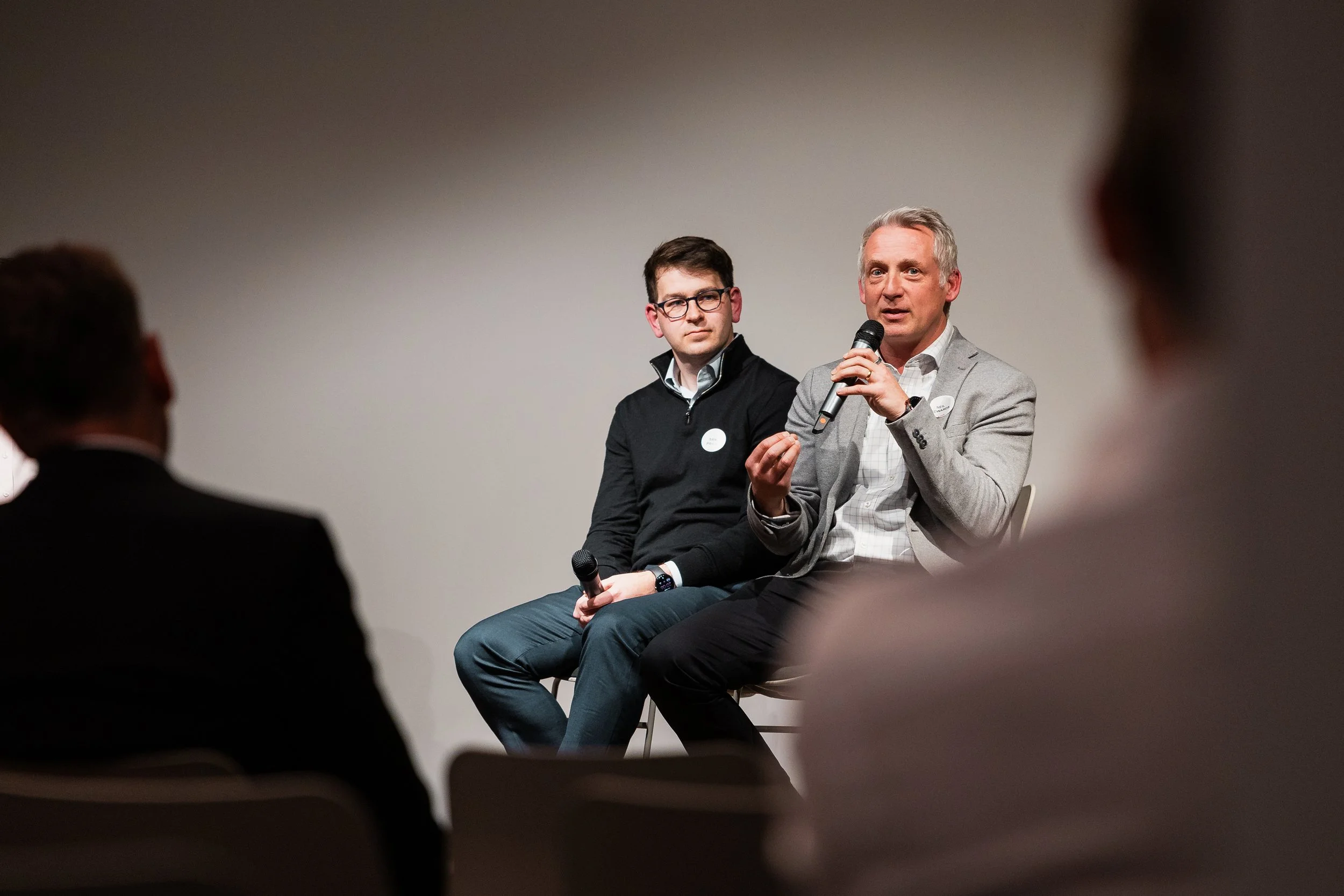 Two men talking on stage at a business presentation by London Photographer Bobby Shoebotham