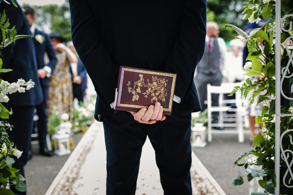 Close up of the back of a wedding officiant, waiting to conduct a wedding ceremony at Moreton House, North Devon.
