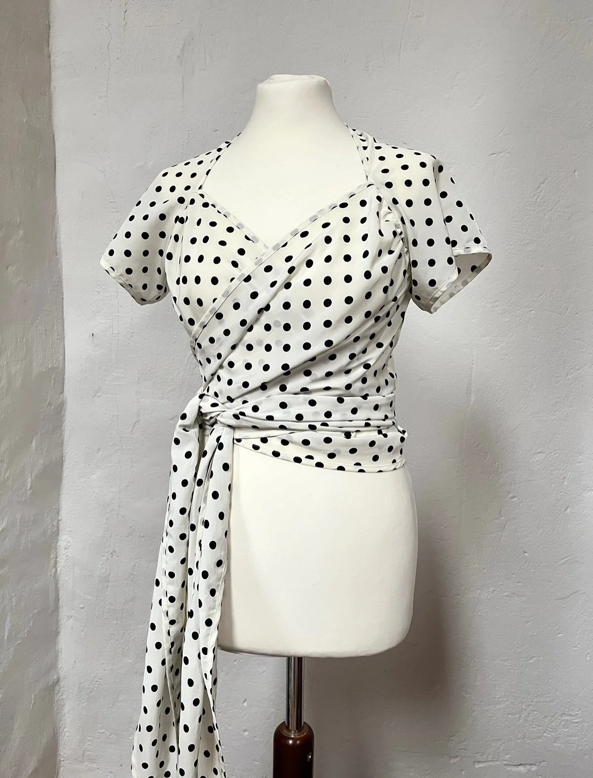 Launched in 1988, Moschino Cheap and Chic embodied the whimsical and quirky aesthetic of Franco Moschino (1950-1994). This beautiful wrap top with polka dots is a beautiful example of a playful, yet elegant piece to cherish again and again 🤍🖤🤍🖤

