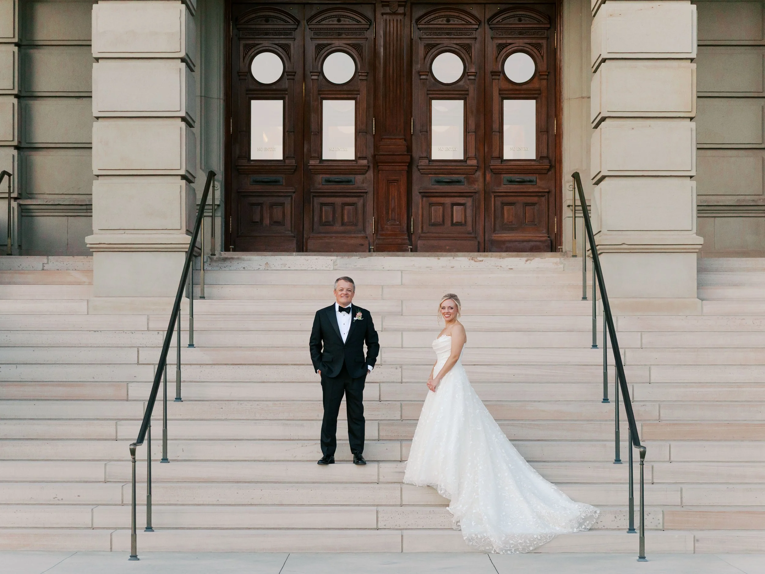 Bride and Groom in on Cheyenne, Wyoming Captiol Building steps both smiling as the camera