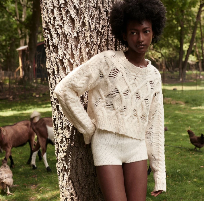 Model wearing Aisling Camps cream cropped cable sweater and cream knit shorts