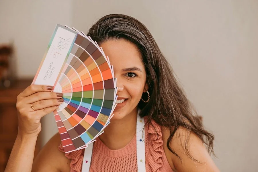 woman holding color swatches thinking about visuals that best describe her brand