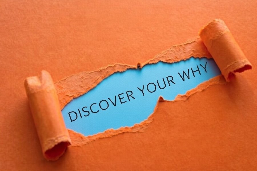 construction paper unfurling to reveal a text that says discover your why