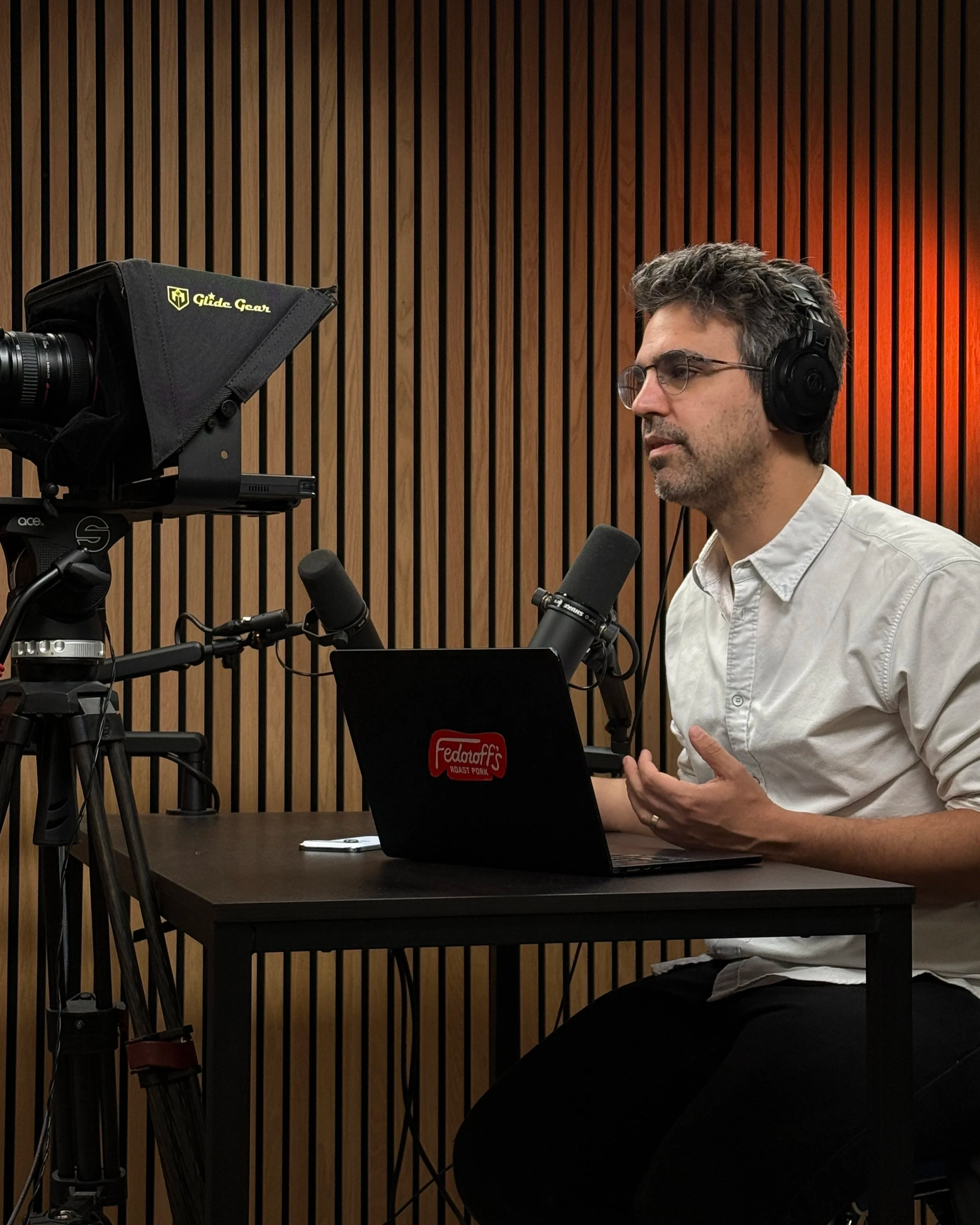 Podcast host recording at Upstate Podcast Studio with teleprompter and microphone setup for remote guest sessions in the Hudson Valley