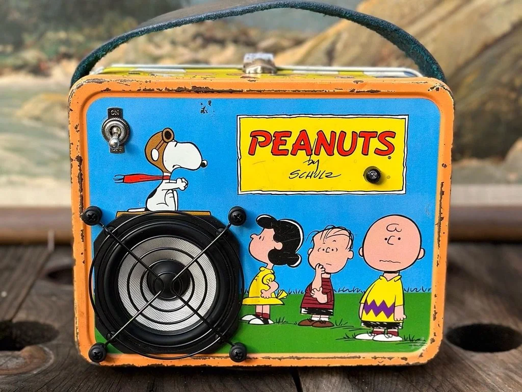 Vintage Peanuts-themed amplifier with Snoopy and characters on front panel.