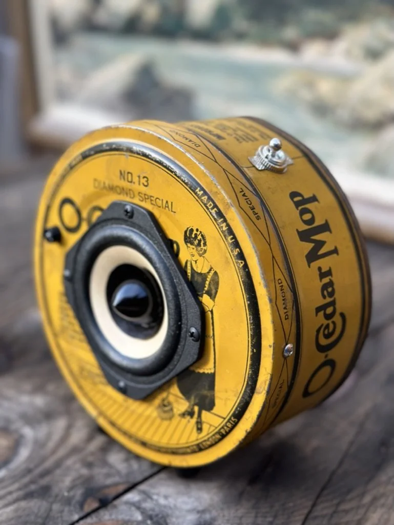 Vintage O-Cedar Mop tin repurposed into a speaker, set on a wooden surface.