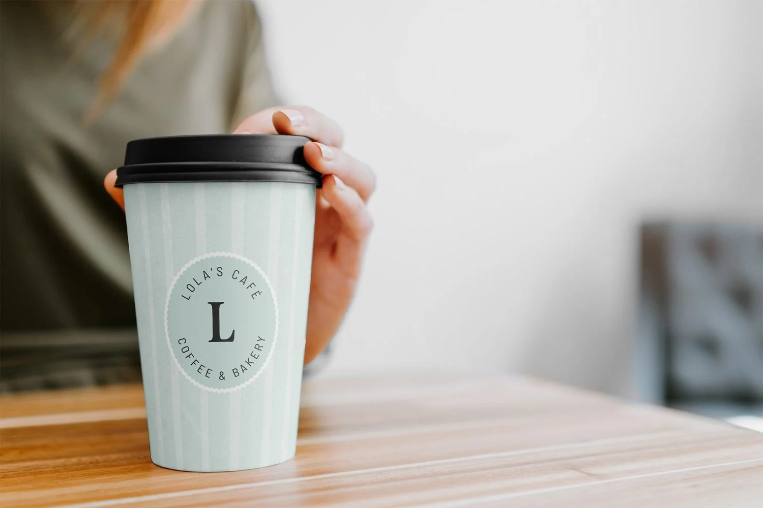 Coffee cup branding with Lola's Cafe branding. Blue watercolour striped pattern with Scalloped oval submark.