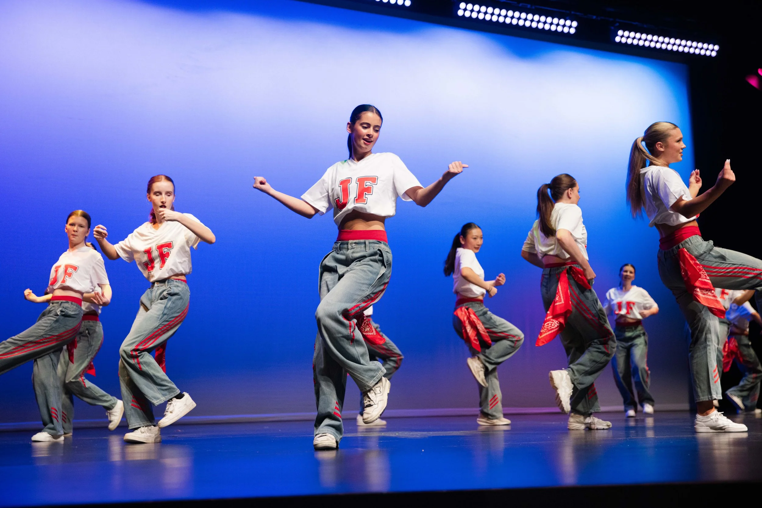 Dancer in a dynamic pose wearing a red outfit on stage