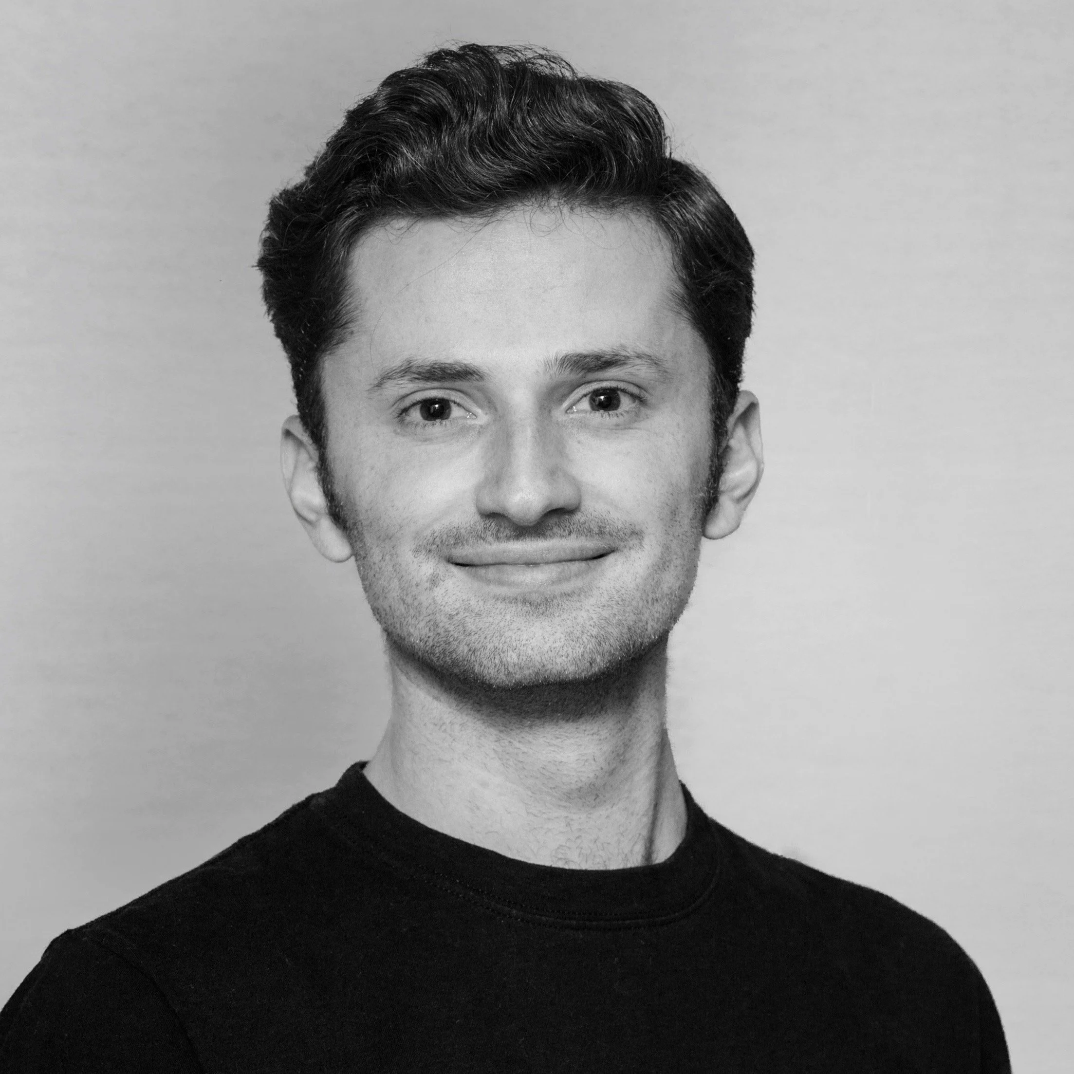 Smiling person in black shirt with neutral background