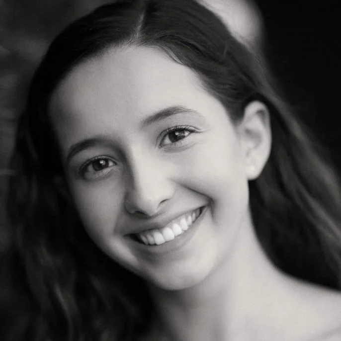 Black and white portrait of a smiling person with long hair.