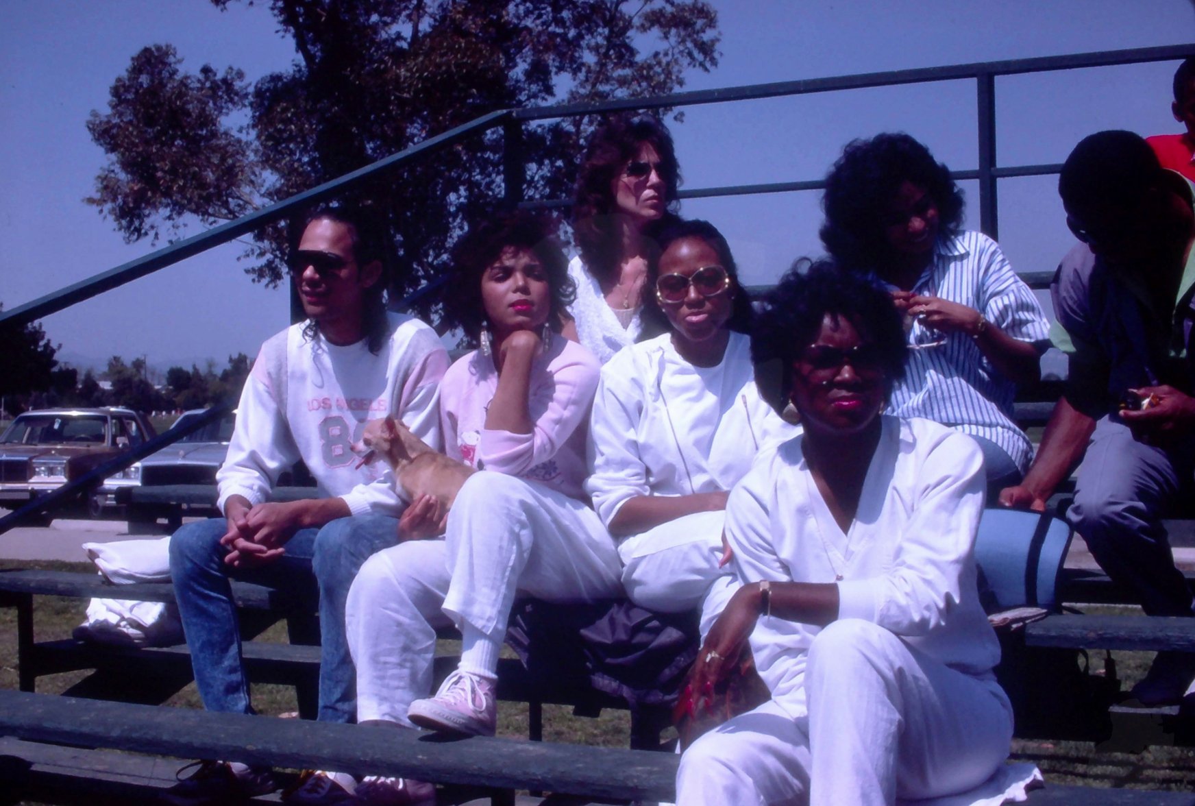 James DeBarge & Janet Jackson sit with friends at the Jackson Family softball game. Los Angeles, California, May 1985.