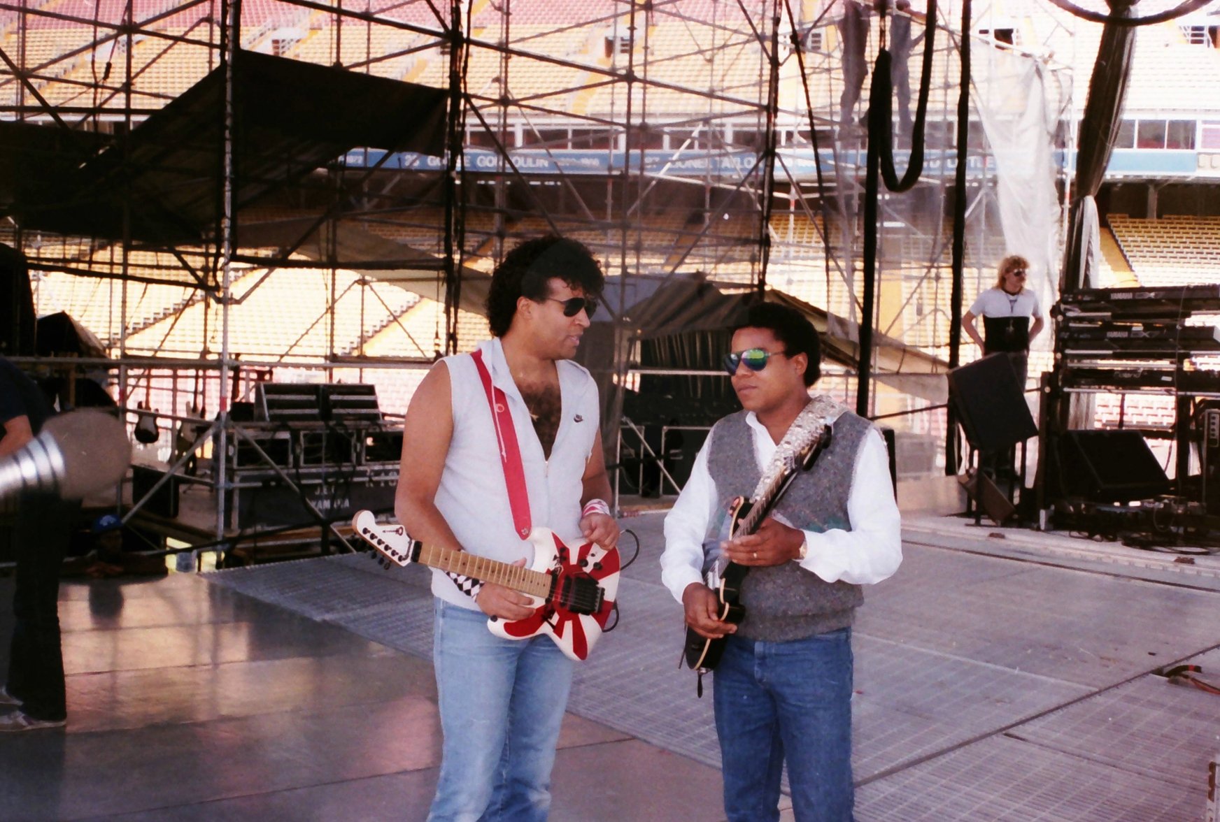 Tito Jackson speaks to the Jacksons guitar man during sound check on the Victory Tour, Dodger Stadium, Los Angeles, California, December 1984.