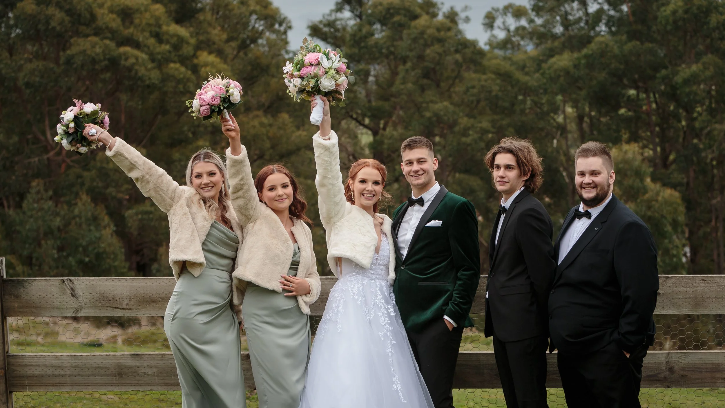 T and J and their wedding party. Bouquets in the air in triumph! 
Photo credit: Alan Rogers Photography.