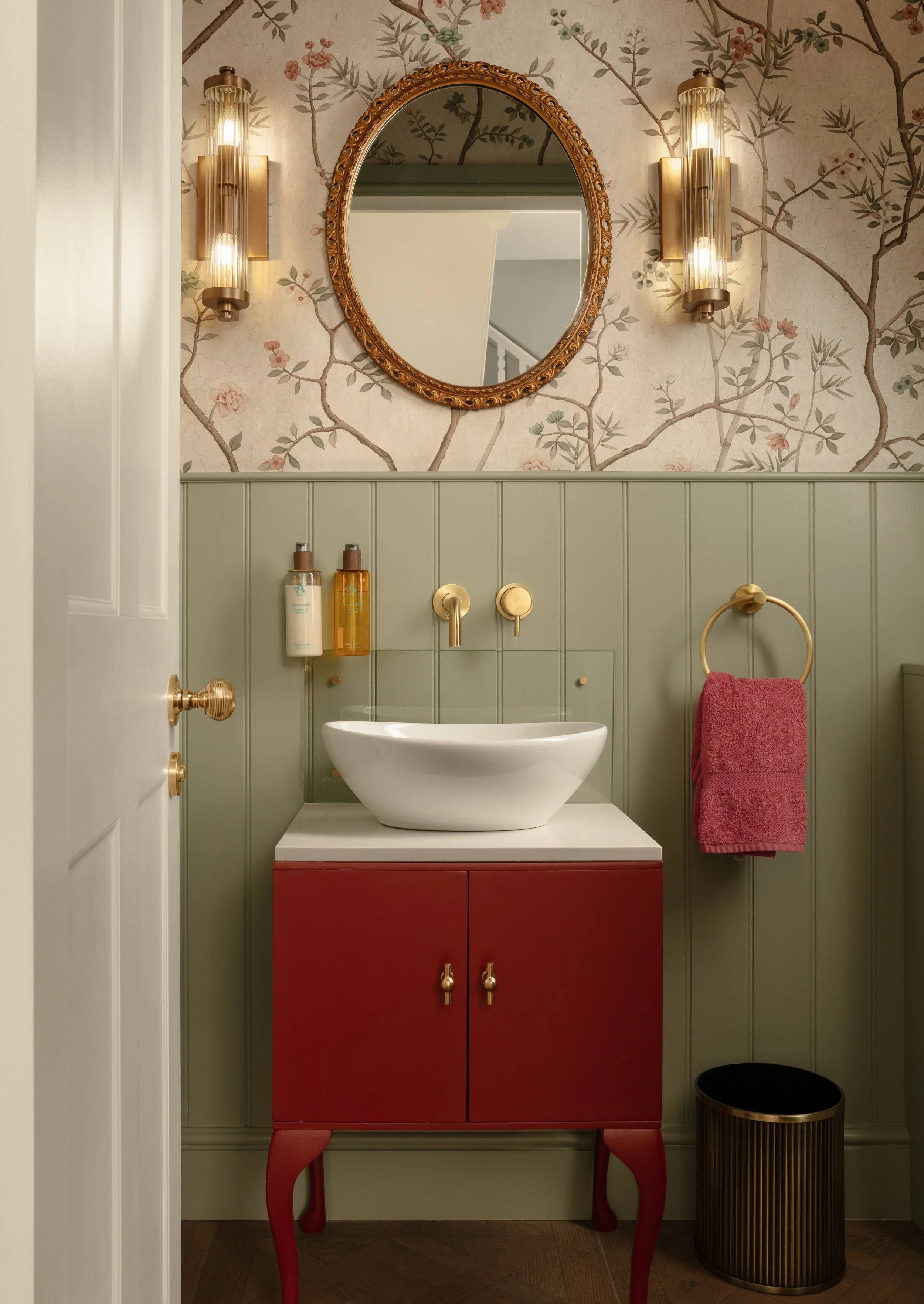 Statement period cloakroom with red, vintage bathroom unit. Wallpapered and panelled wall. 