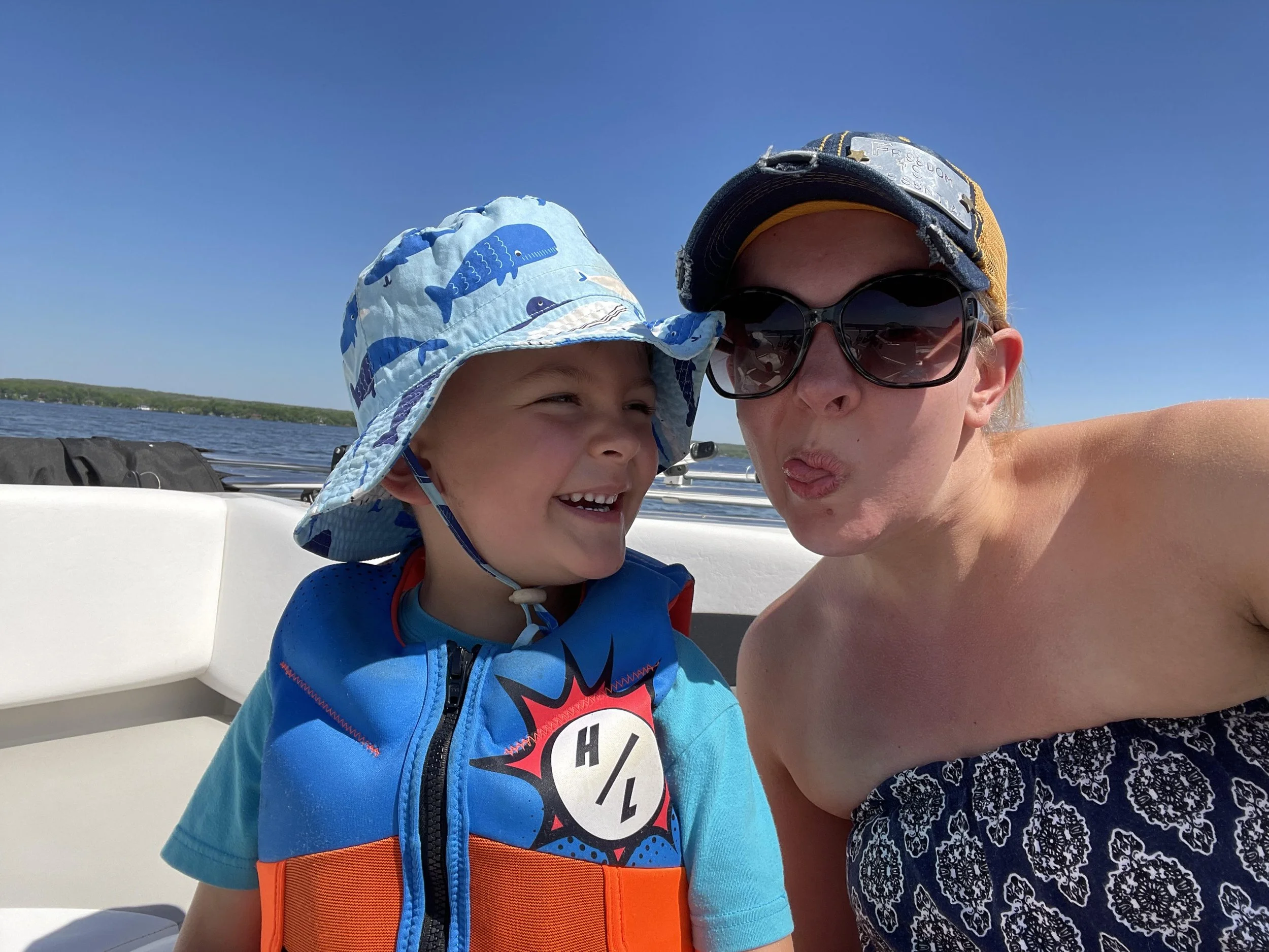 Mother and sun making silly faces at each other on boat