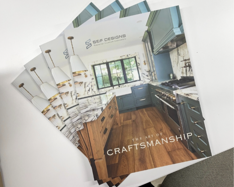 A brochure for Seif Designs showcasing a modern kitchen with blue cabinets, marble countertops, and wooden flooring.