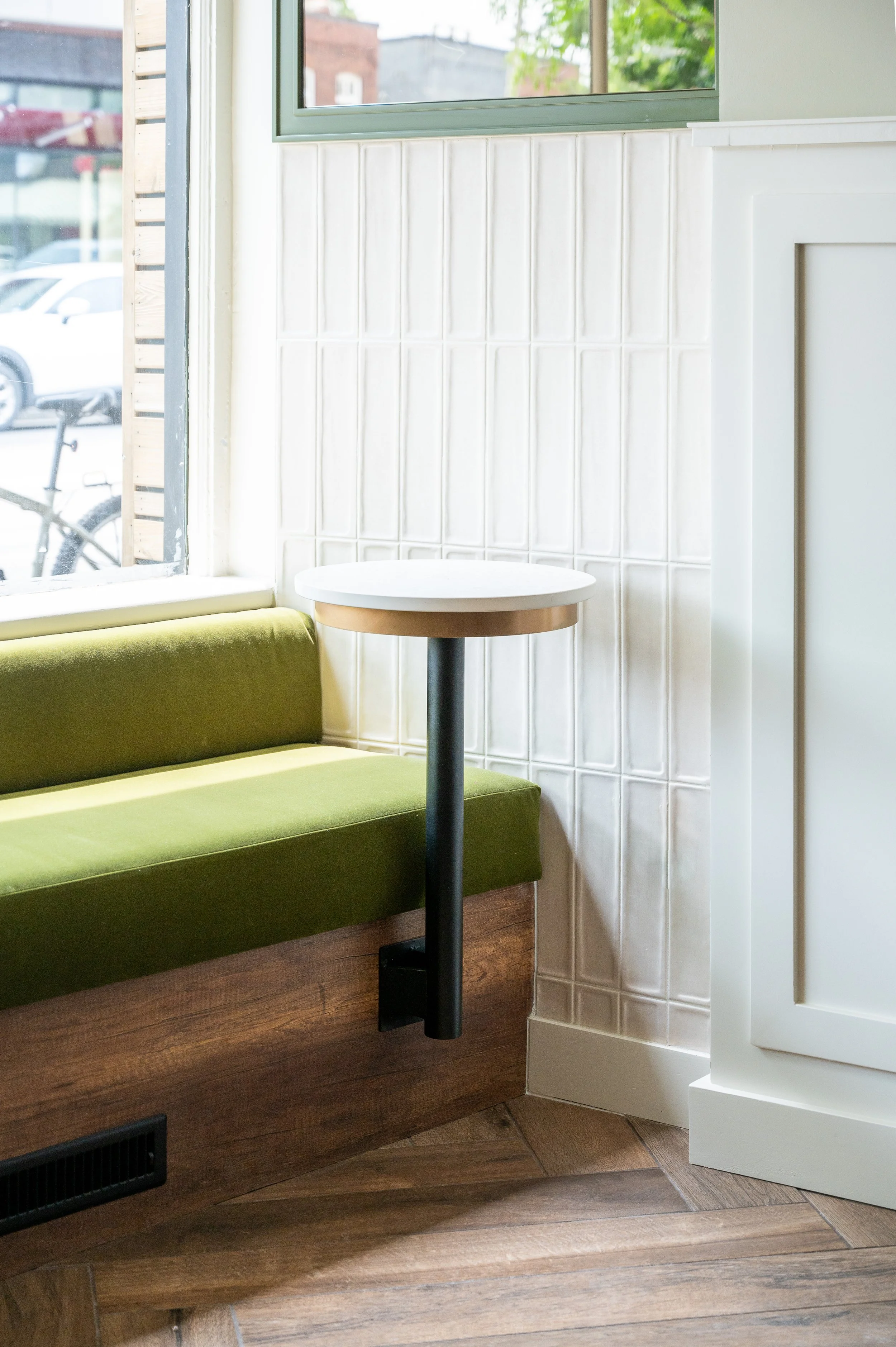 This chic café interior boasts sleek wooden shelves and curved lighting with greenery, set against a backdrop of soft green tiles. The combination of natural wood and modern design creates a warm, inviting atmosphere for coffee enthusiasts.
Discover 
