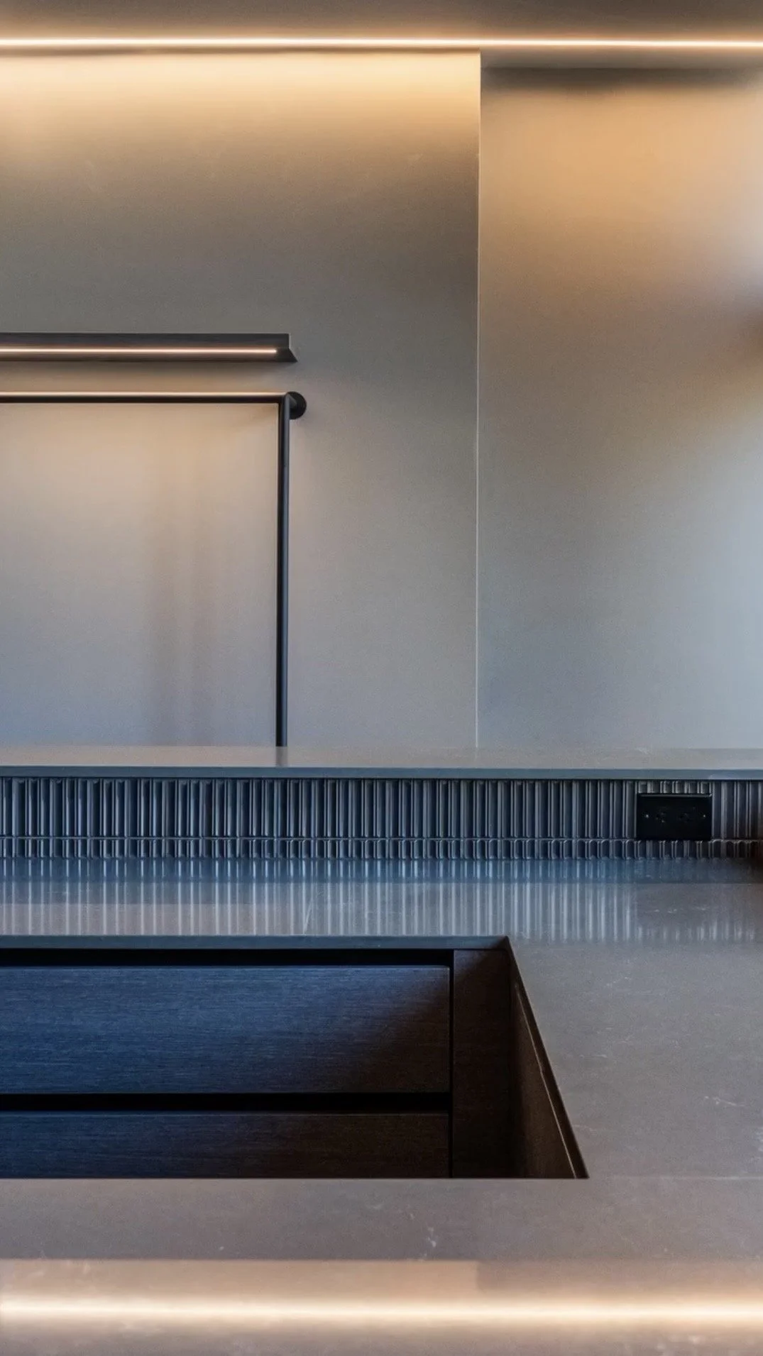 Modern kitchen countertop with a textured backsplash and an electrical outlet.