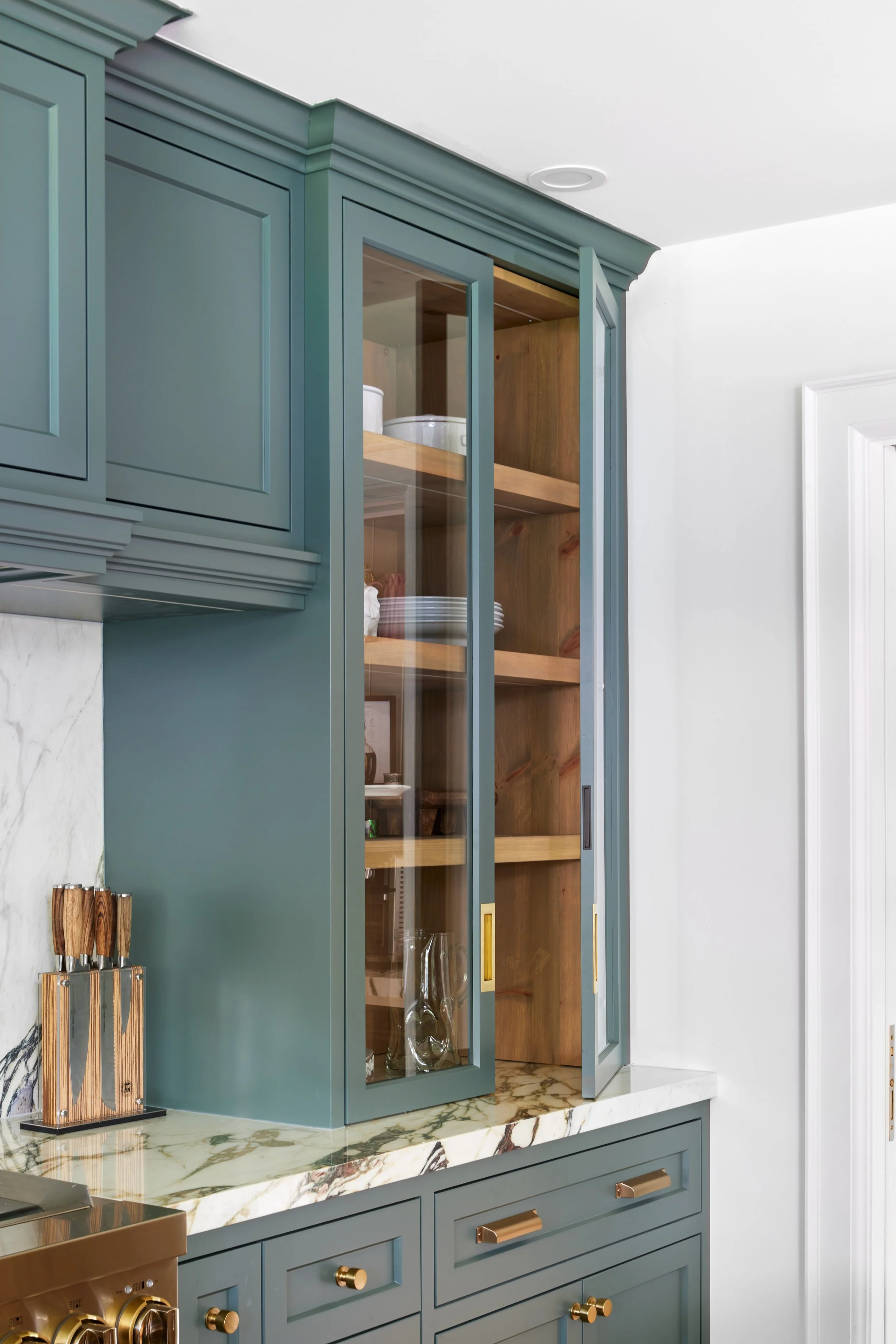 High-end custom modern kitchen in Mississauga, Oakville and Toronto, Ontario. Features trends color for 2024, luxurious gold hardware, and a marble countertop. Serving millwork and cabinetry accross GTA. 