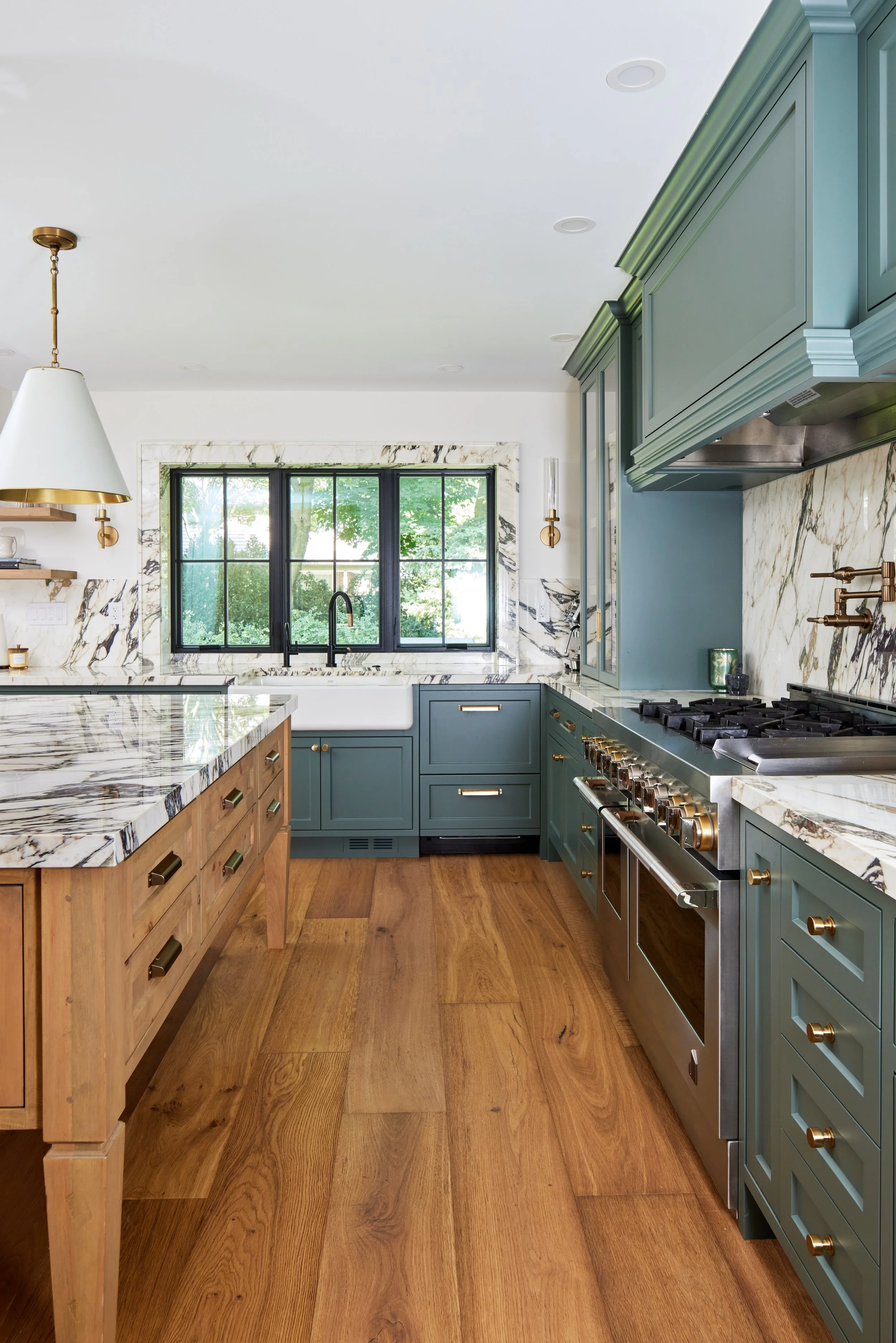 
High-end custom modern kitchen in Mississauga, Oakville, and Toronto, Ontario. Features trends color for 2024, luxurious gold hardware, a marble countertop, and an elegant kitchen sink. Serving millwork and cabinetry across the GTA.