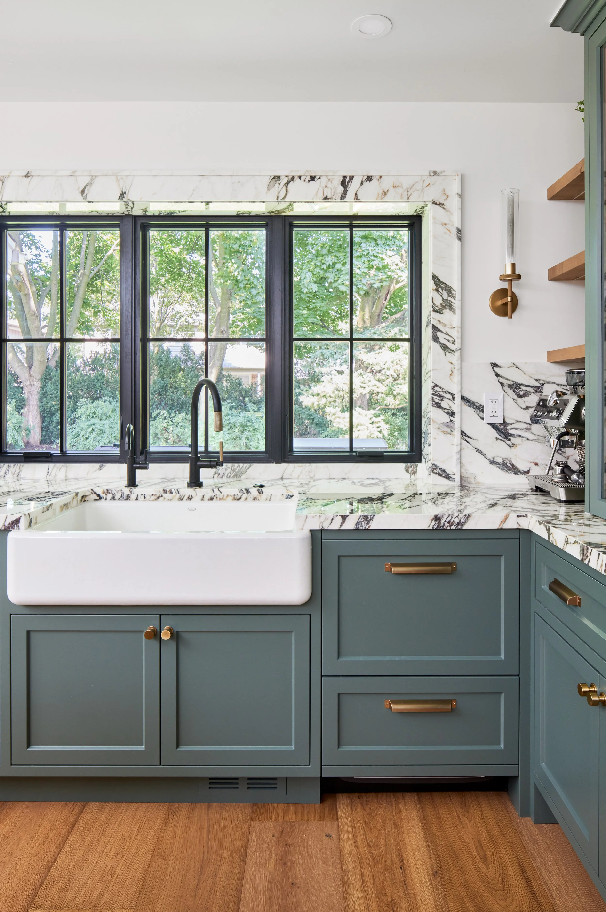 
High-end custom modern kitchen in Mississauga, Oakville, and Toronto, Ontario. Features trends color for 2024, luxurious gold hardware, a marble countertop, and an elegant kitchen sink. Serving millwork and cabinetry across the GTA.