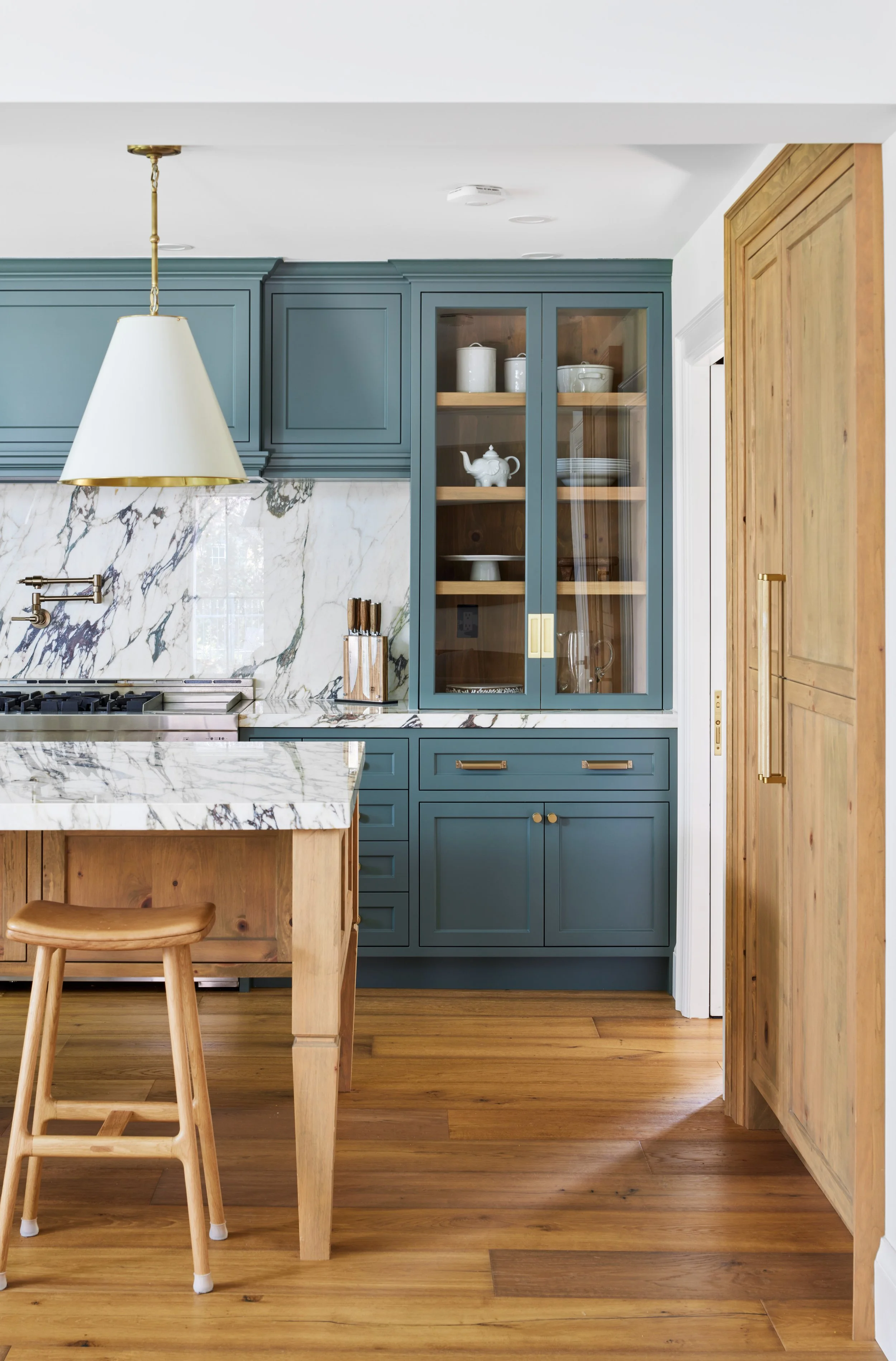 High-end custom modern kitchen in Mississauga, Oakville and Toronto, Ontario. Features trends color for 2024, luxurious gold hardware, and a marble countertop. Serving millwork and cabinetry accross GTA. 