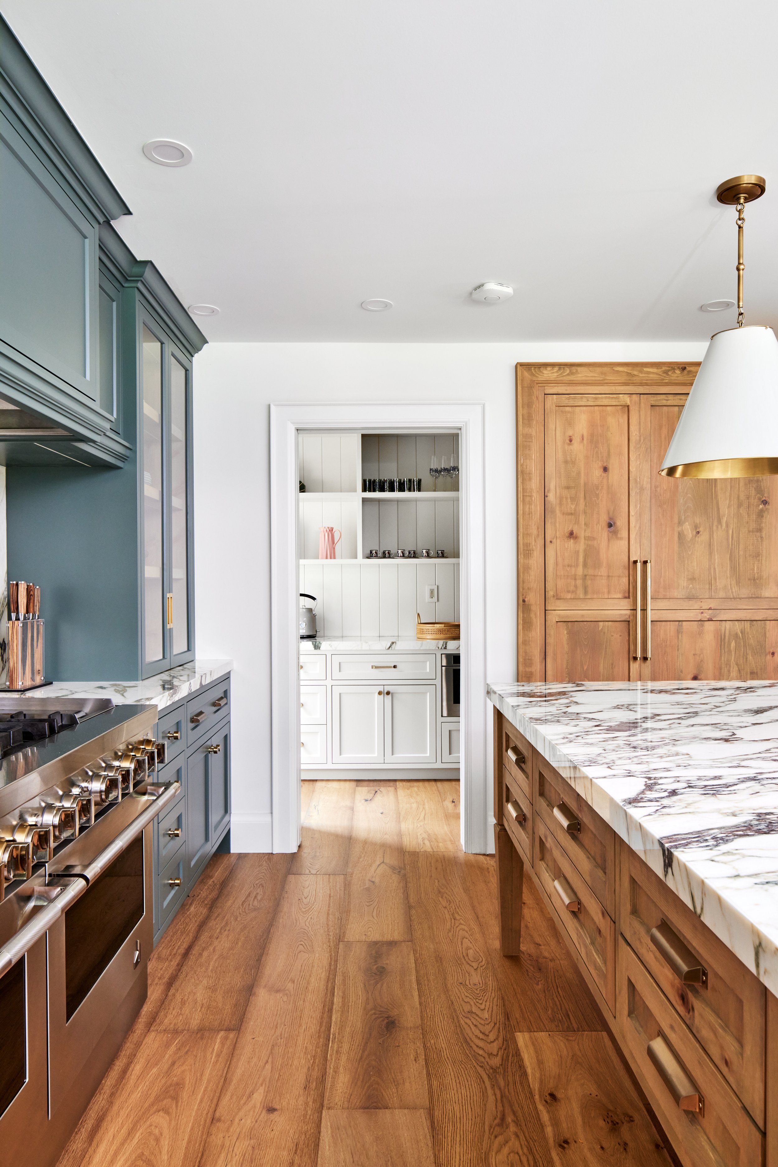 High-end custom modern kitchen in Mississauga, Oakville and Toronto, Ontario. Features trends color for 2024, luxurious gold hardware, and a marble countertop. Serving millwork and cabinetry accross GTA. 