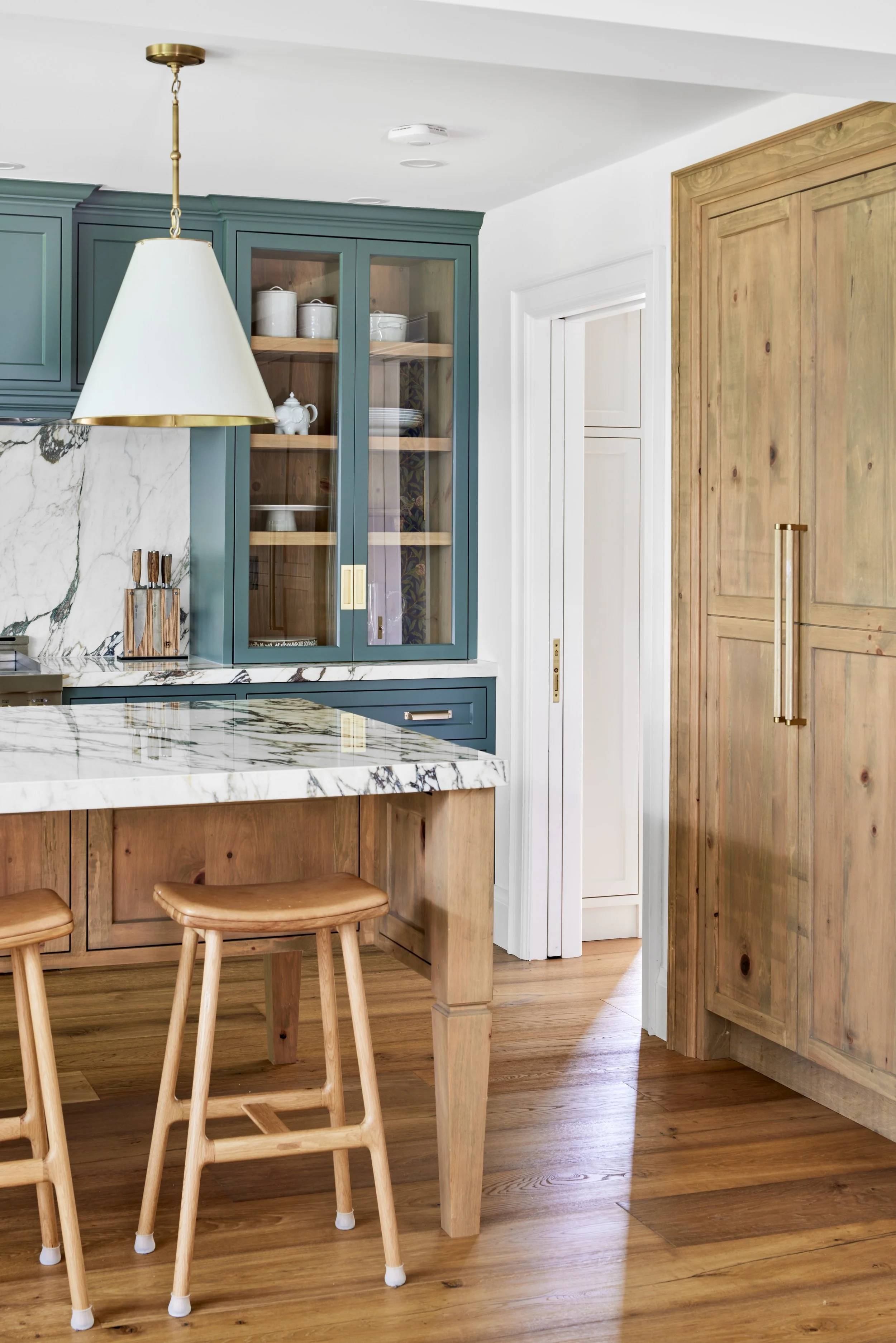 High-end custom modern kitchen in Mississauga, Oakville and Toronto, Ontario. Features trends color for 2024, luxurious gold hardware, and a marble countertop. Serving millwork and cabinetry accross GTA. 