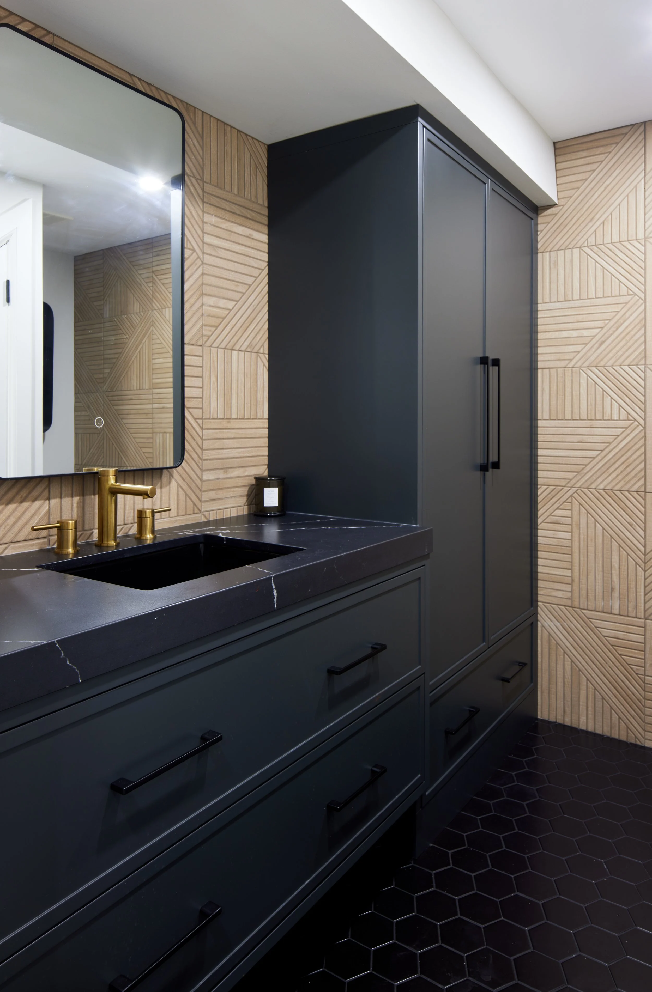Custom closet cabinetry and bathroom vanity in matte black with minimalist handles, cabinet from floor to ceiling to maximize storage with smooth, clean lines design, custom closet with hidden door near me across Greater Toronto Area, Mississauga, Oa