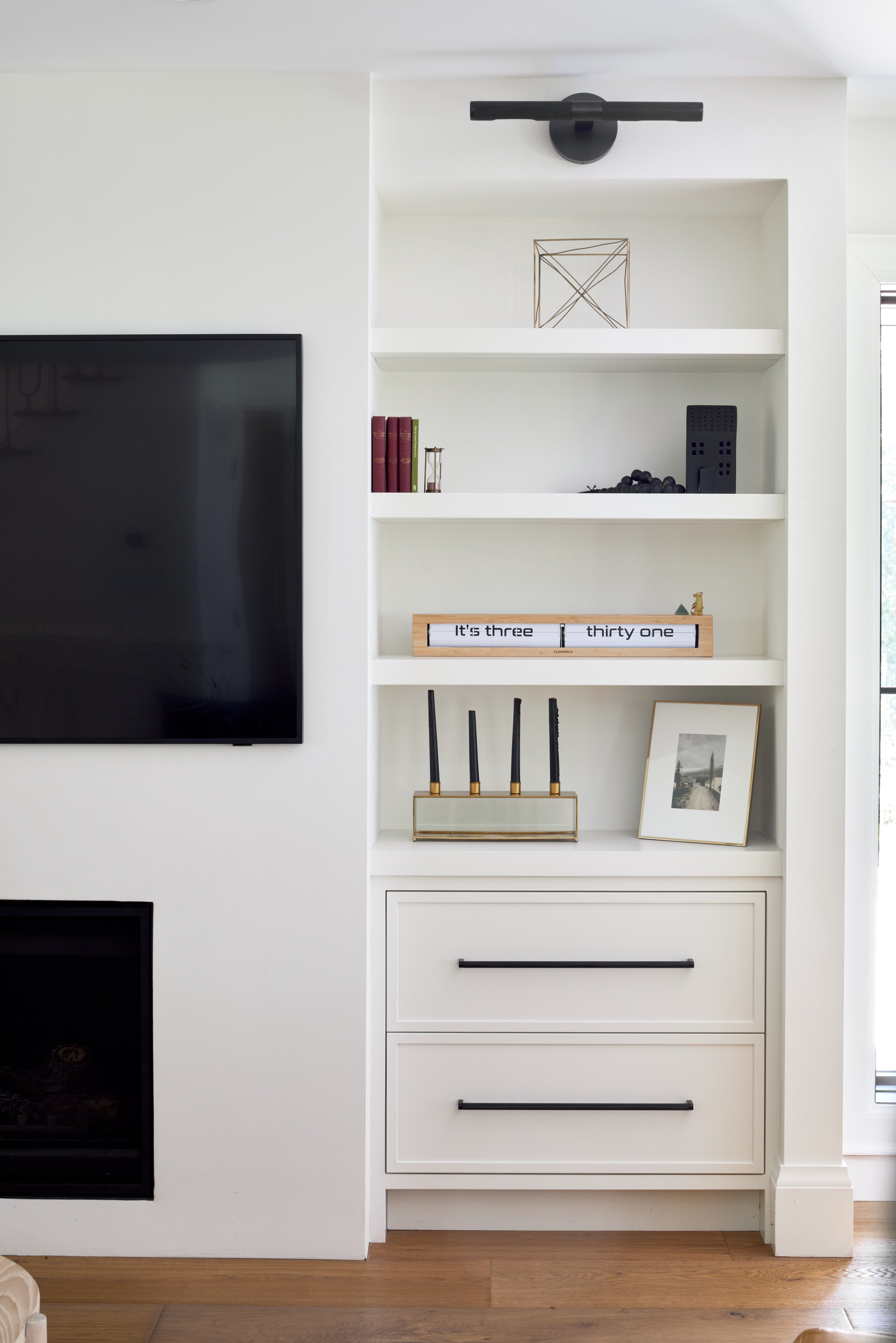 Monochrome custom shelf TV unit, clean and modern cabinets, cabinets with black matte handle, living room and interior renovations Oakville Mississauga and Toronto, serving custom cabinetry and renovation accross Greater Toronto Area.
