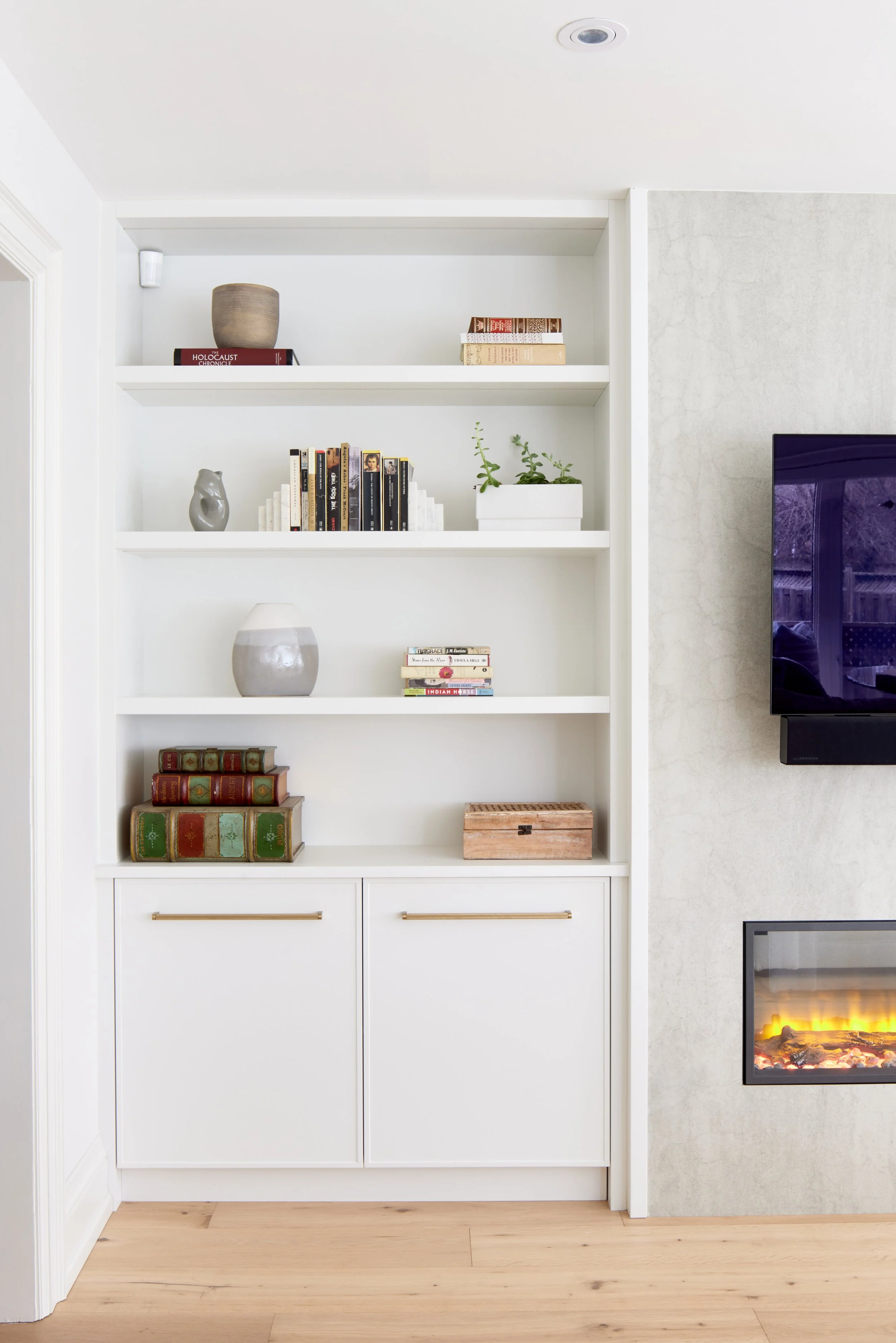 This cozy living room blends style with comfort, featuring a minimalist design with soft-toned sofas perfect for relaxing or hosting guests. A sleek, built-in fireplace adds a touch of elegance, creating a warm and inviting atmosphere.