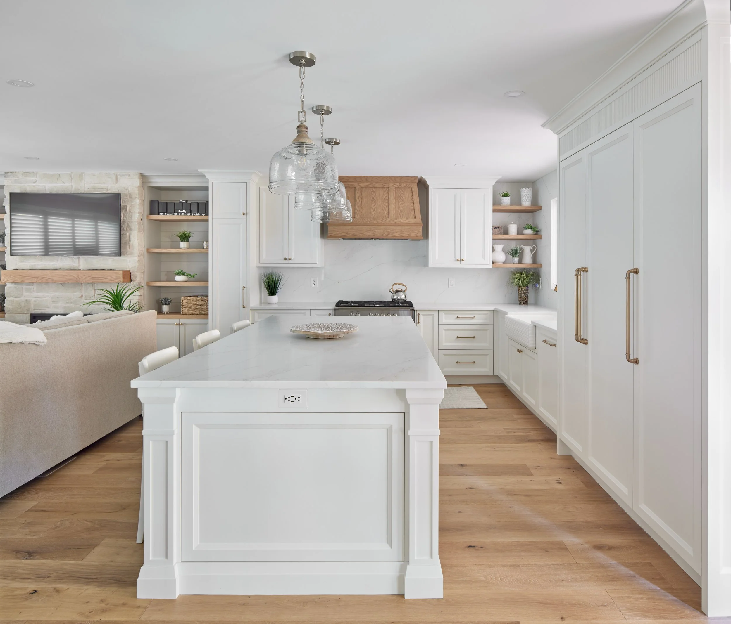 Modern custom kitchen features high-end brass fixtures and an undermount sink. High-end custom modern kitchen in Mississauga, Oakville, and Toronto, Ontario. Features trends color for 2024, luxurious gold hardware, a marble countertop, an elegant kit