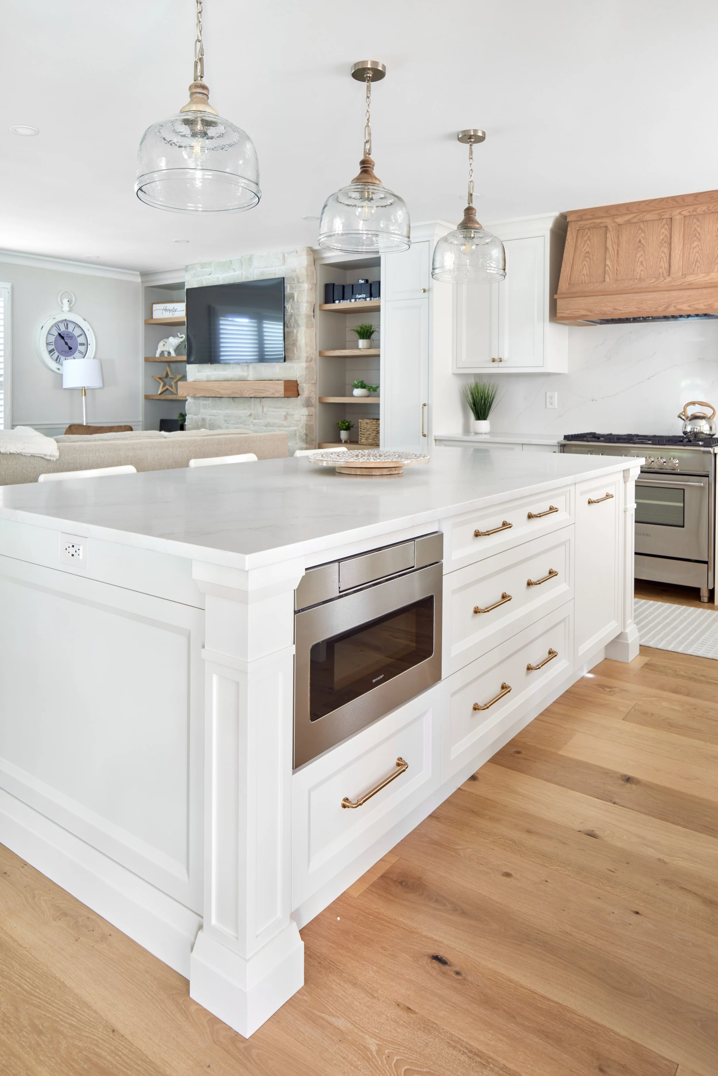 Modern custom kitchen features high-end brass fixtures and an undermount sink. High-end custom modern kitchen in Mississauga, Oakville, and Toronto, Ontario. Features trends color for 2024, luxurious gold hardware, a marble countertop, an elegant kit