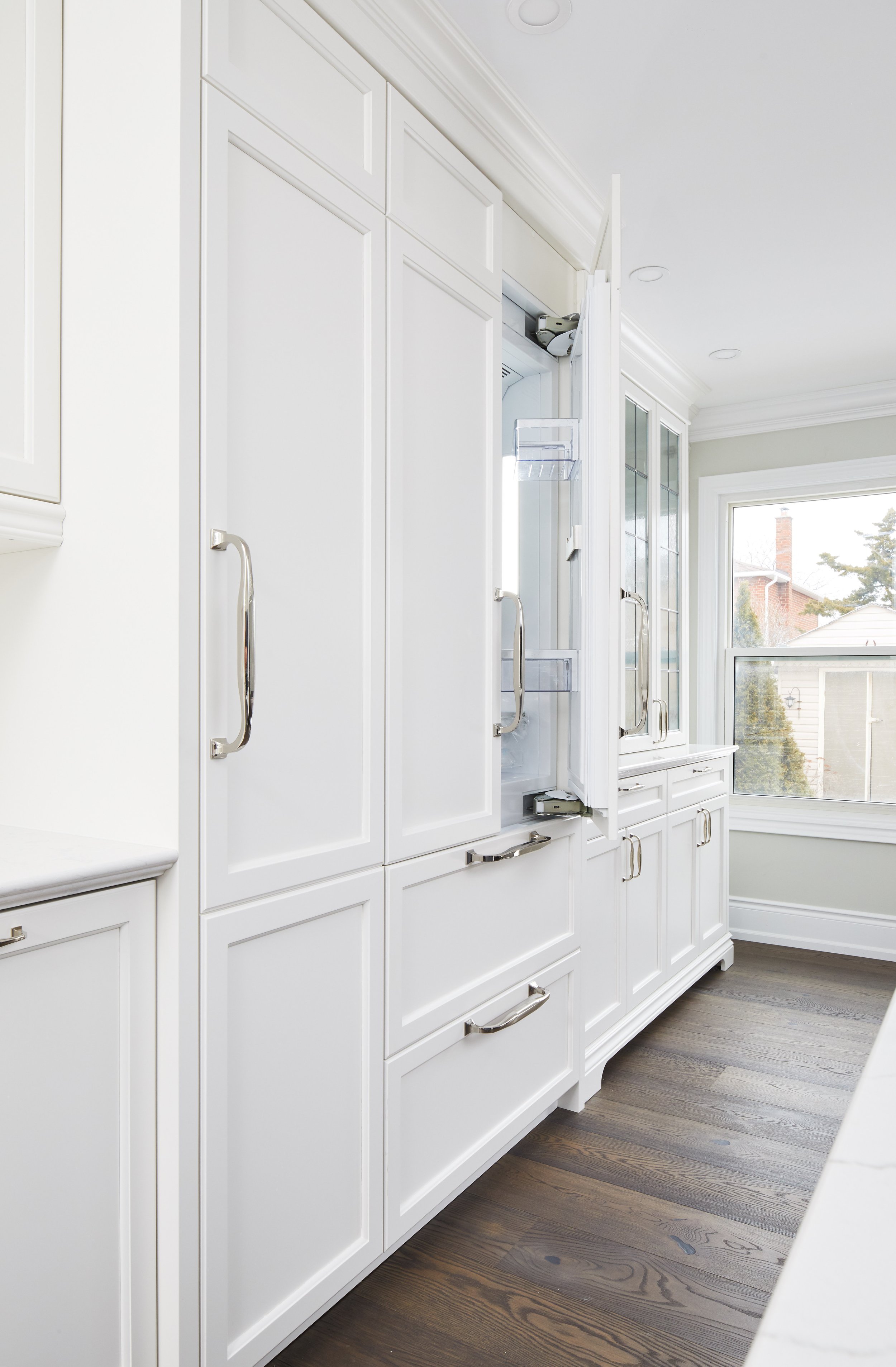 At Seif Designs, we offer top-quality kitchen renovation services around the GTA, Mississauga, Oakville. This traditional kitchen showcases custom white cabinetry with classic detailing and a bold blue island as the focal point. The island features i