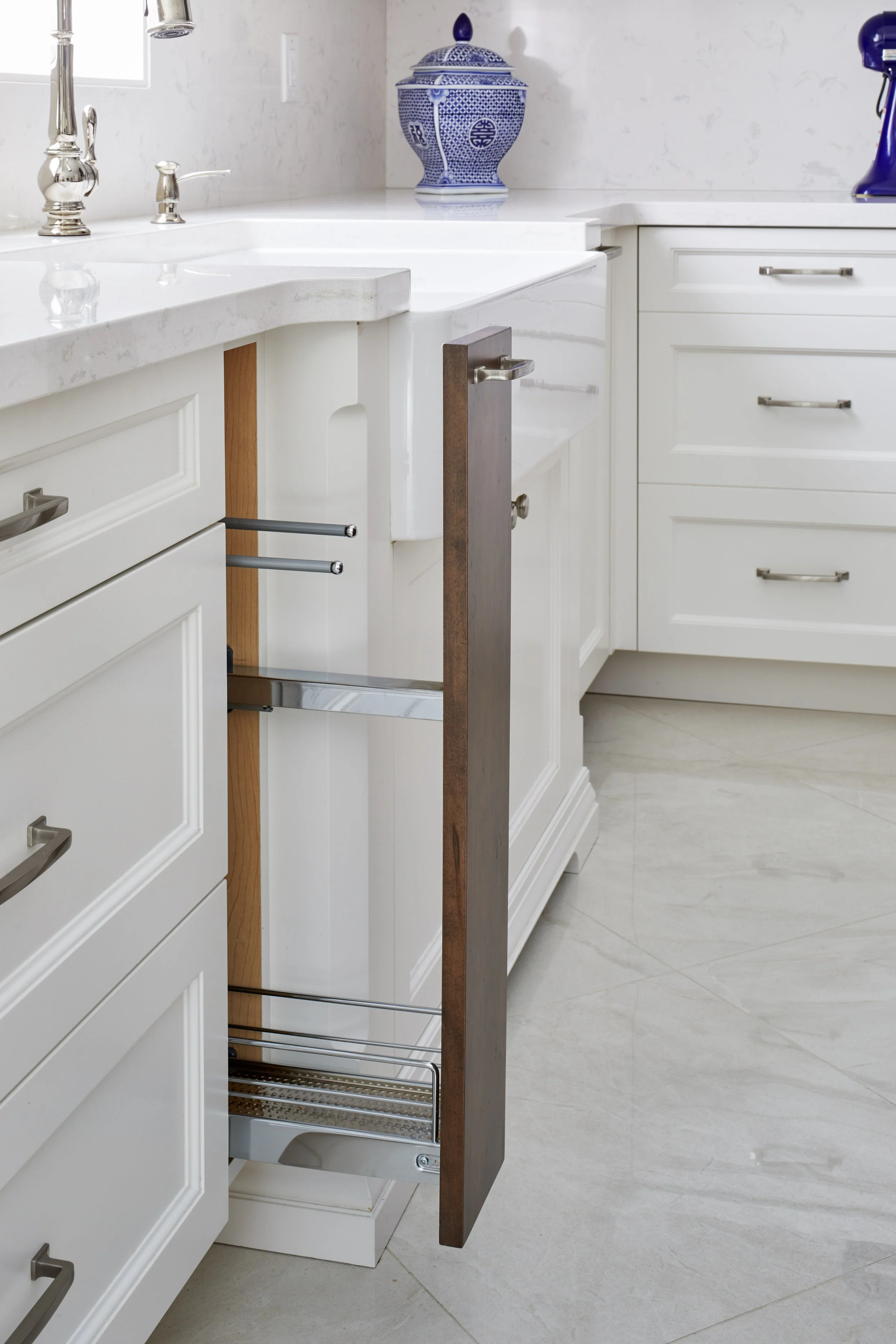 Kitchen cabinet with an open drawer, showing organization and storage space.