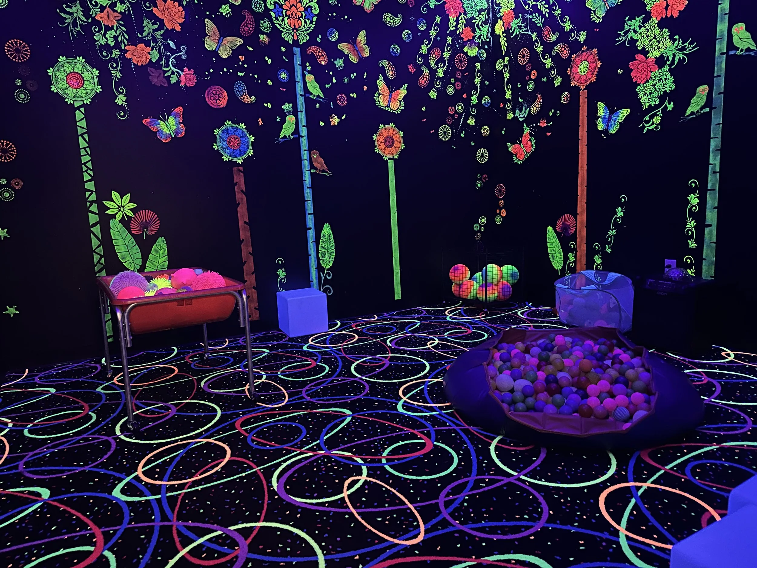 Cool backlit room full of colorful play equipment
