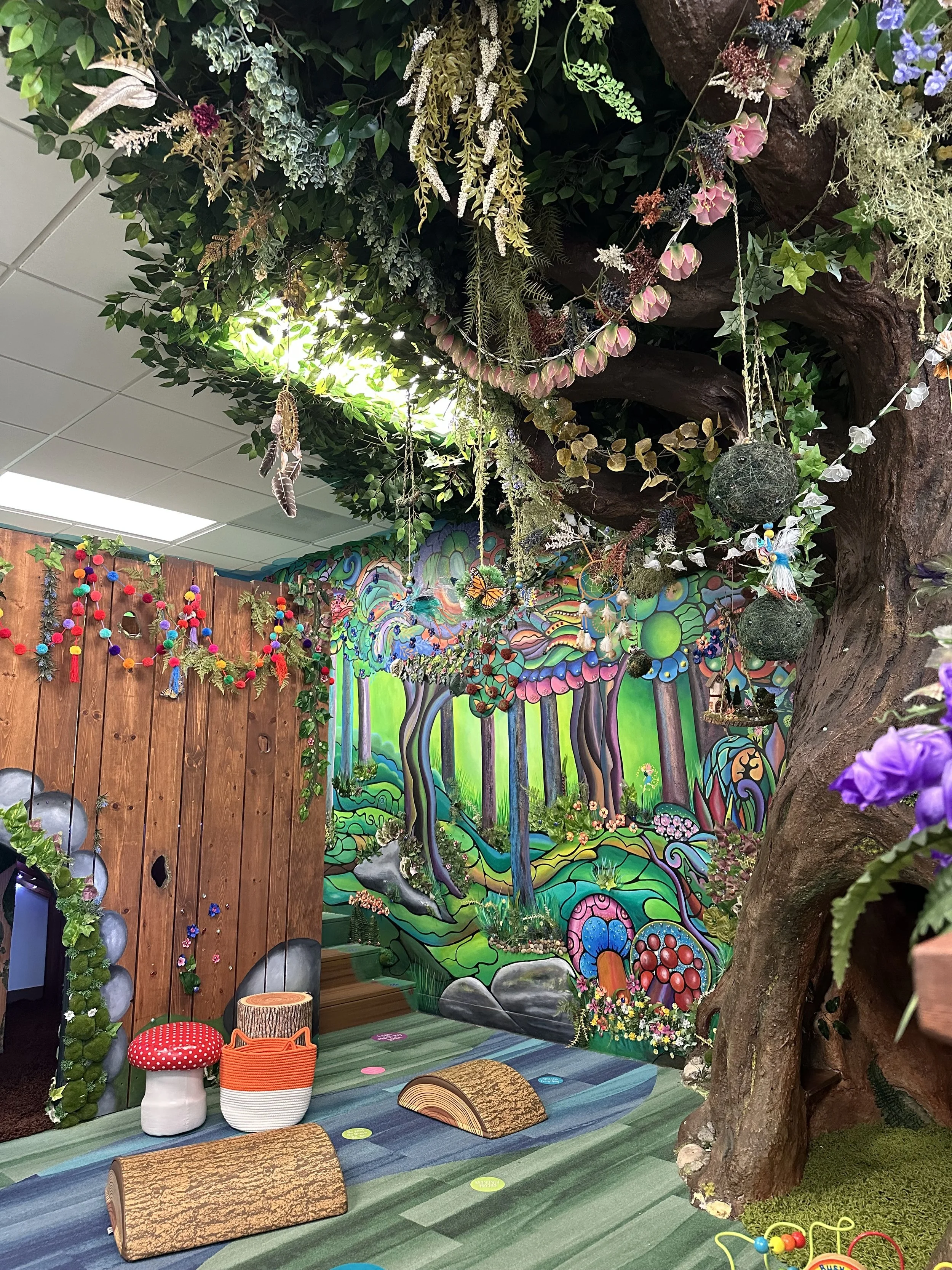 Colorful mural on the wall of a forest themed play area