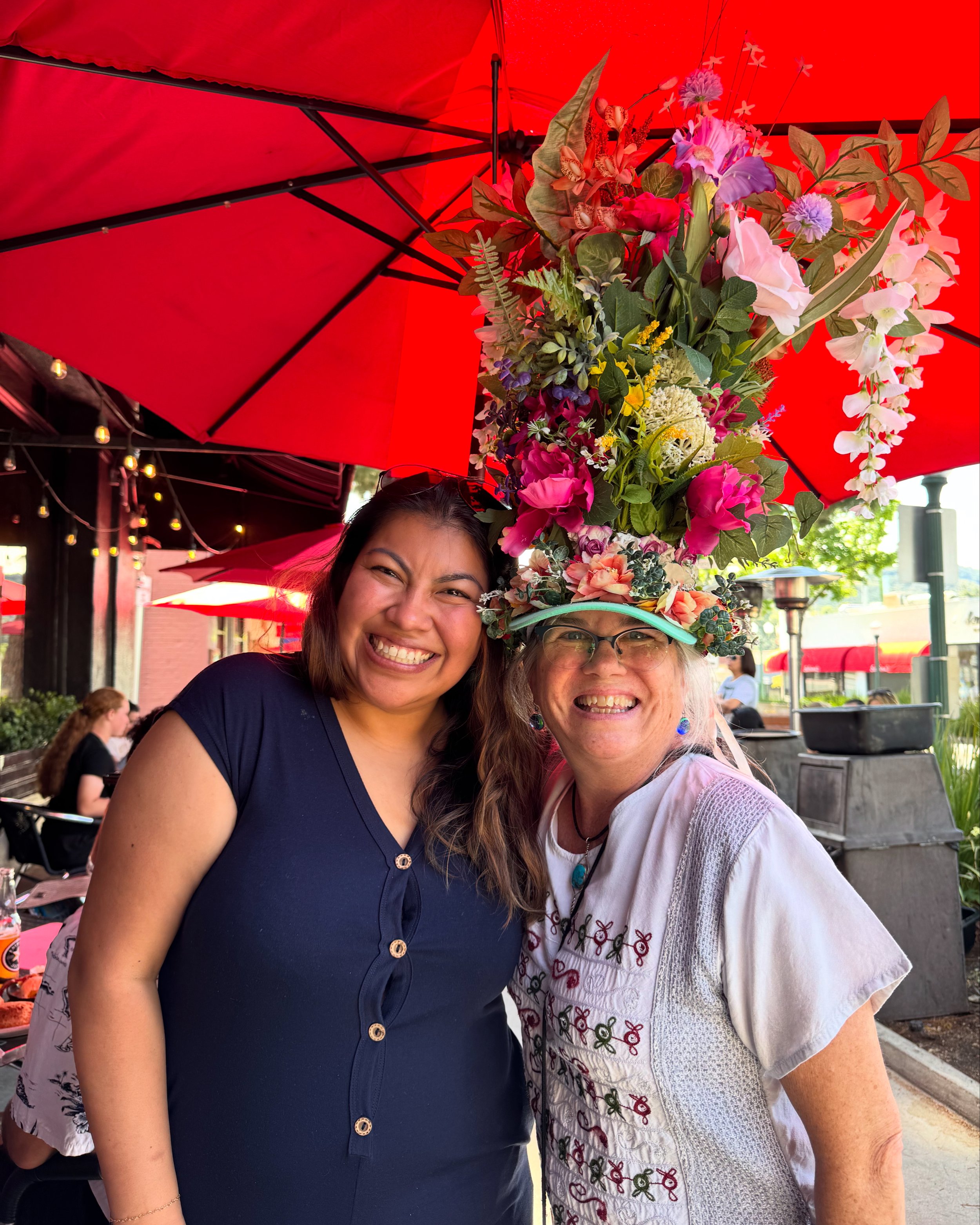 Ms. A with a big hat full of flowers with her friend