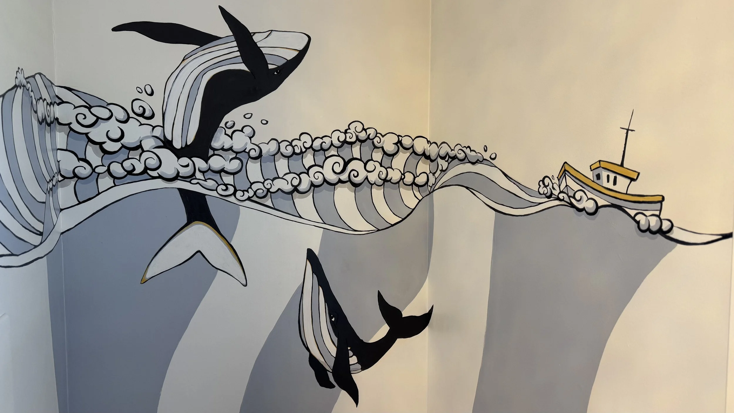 Wall mural of a whale jumping out of the water, with stylized waves and a small boat in the background.