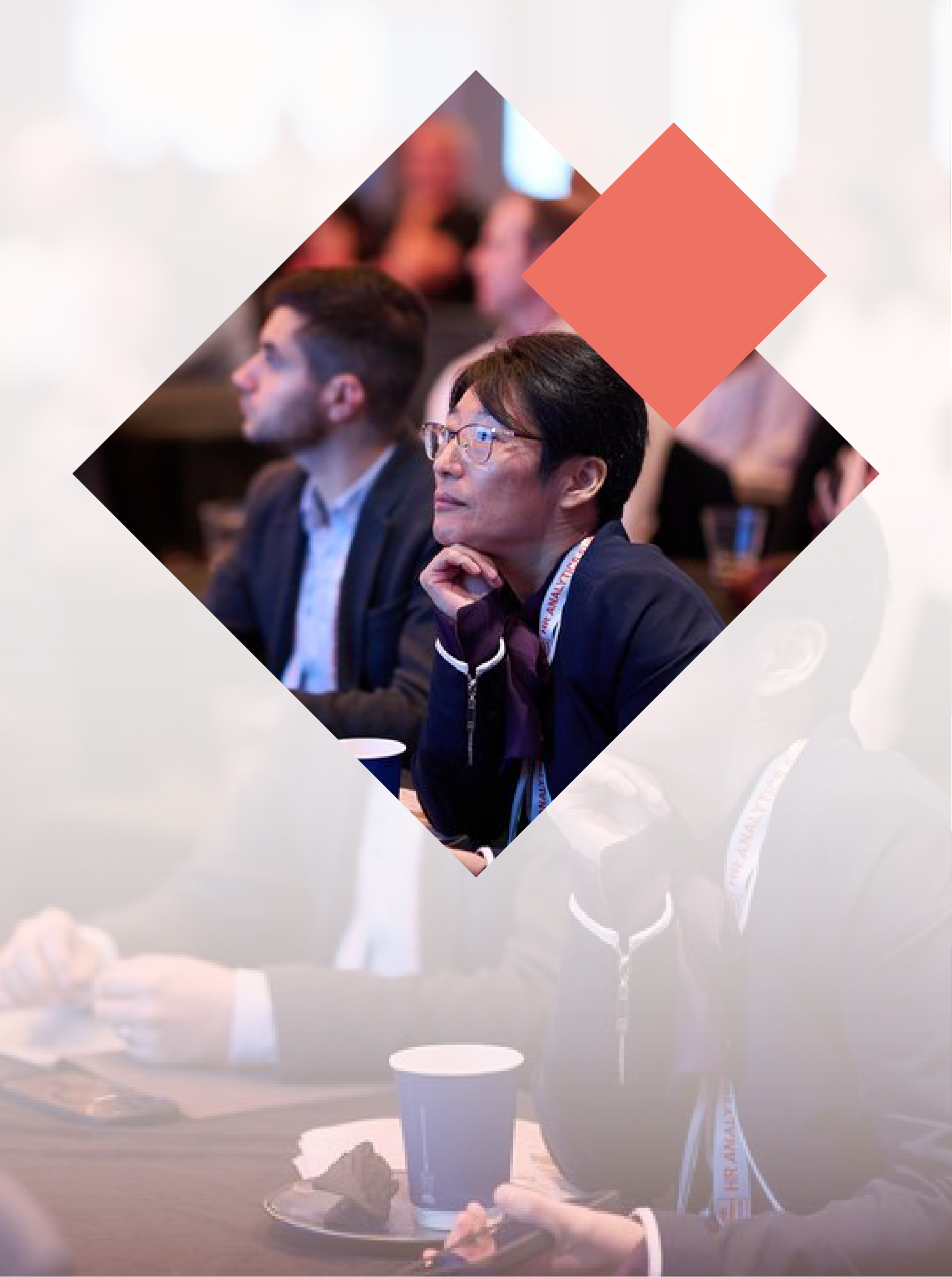 People attentively listening to a presentation at a conference, seated in an audience setting.