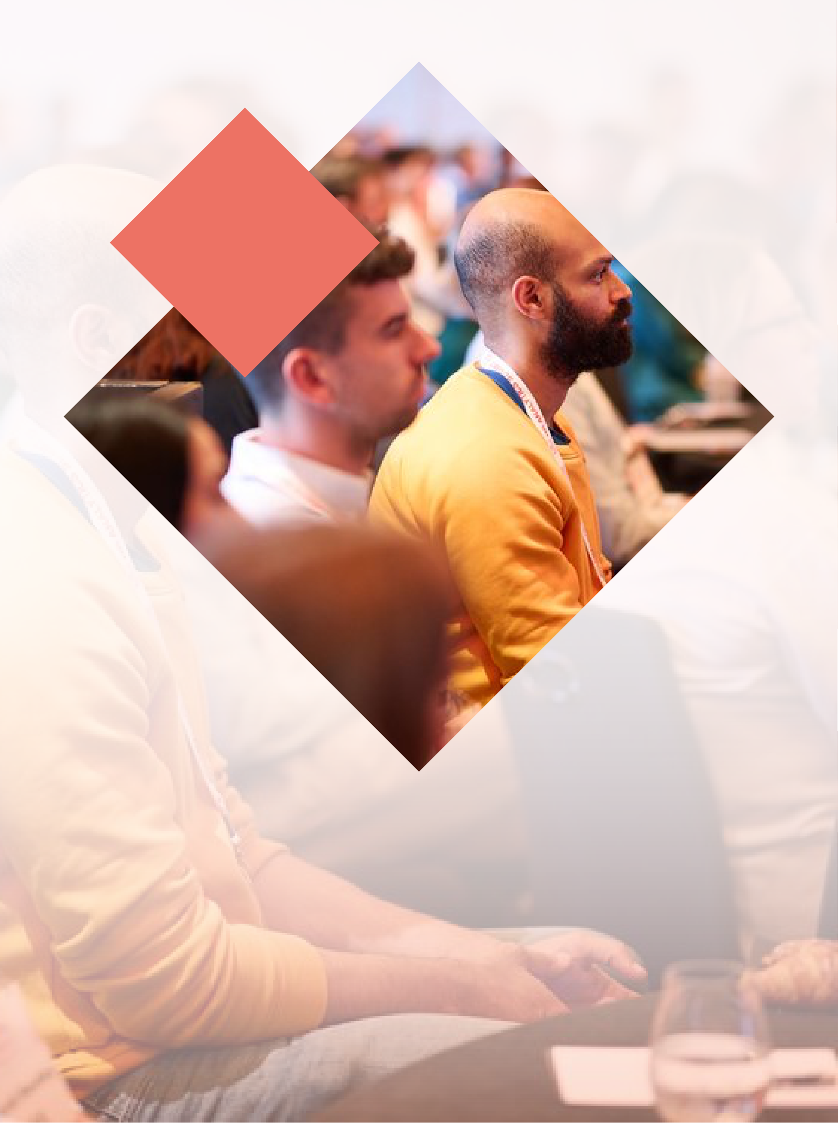 Audience at a conference, man in yellow shirt listening attentively, diamond shape overlay.