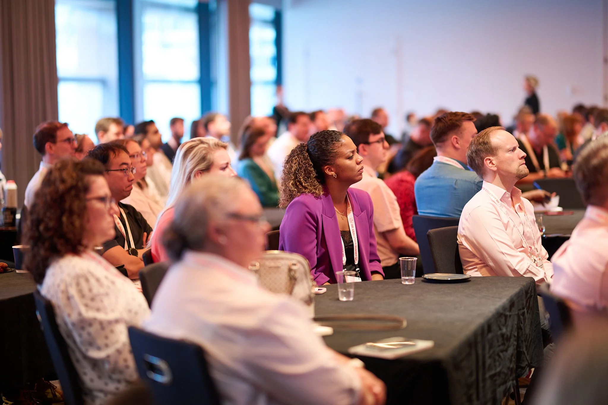 Group of people sitting at tables attending a conference or seminar.