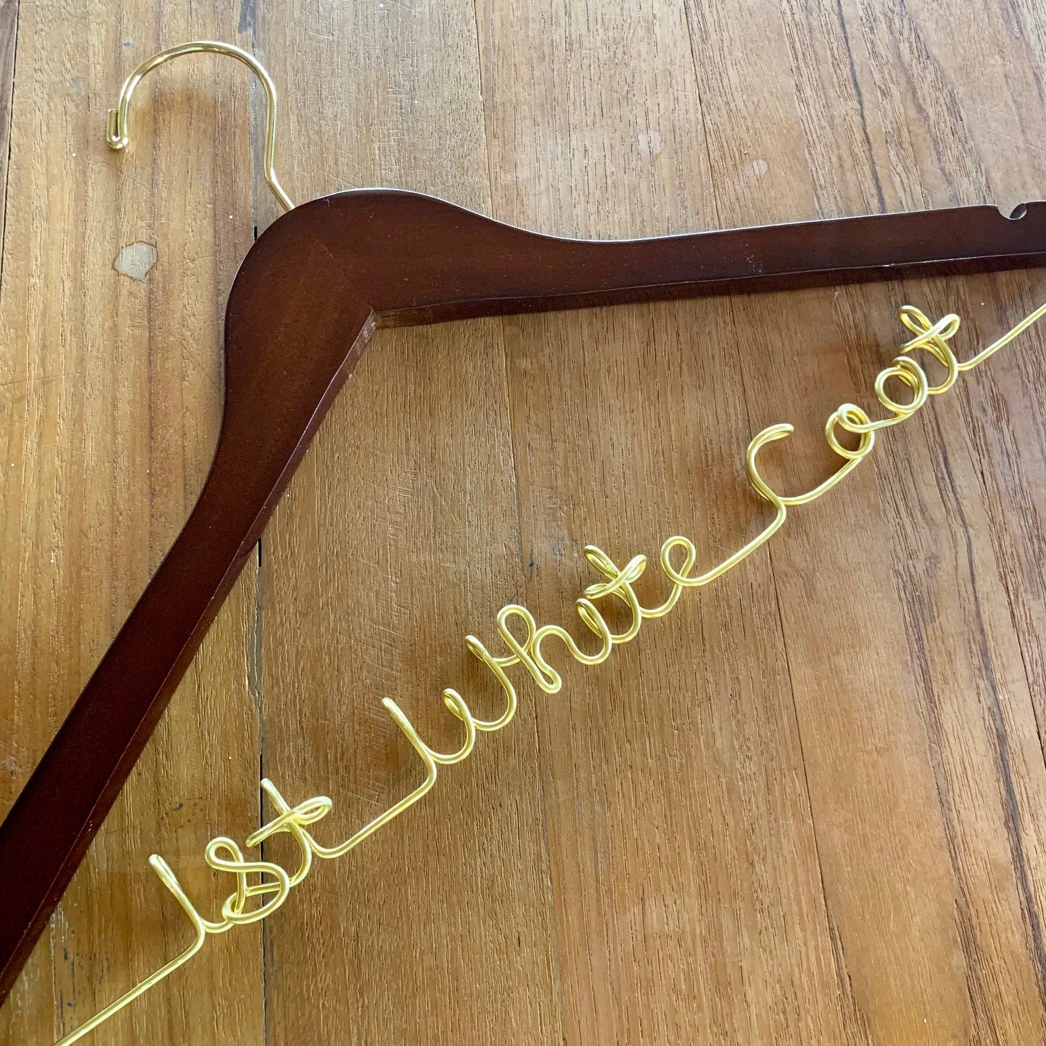gold first white coat hanger