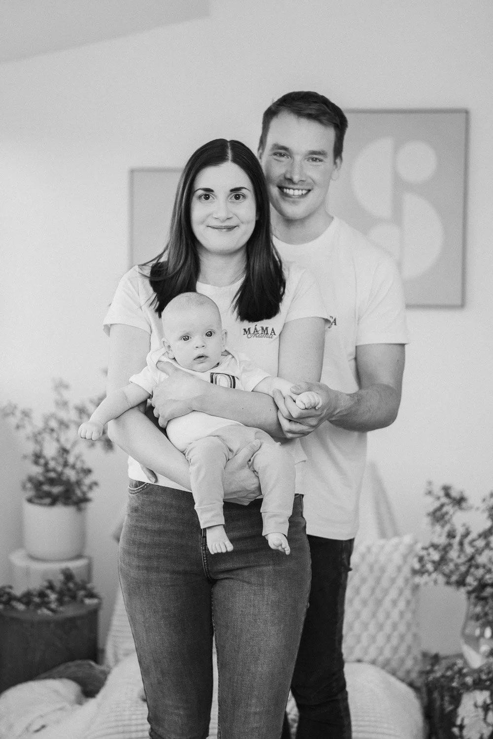 Žena sedí na křesle s miminkem v náručí.