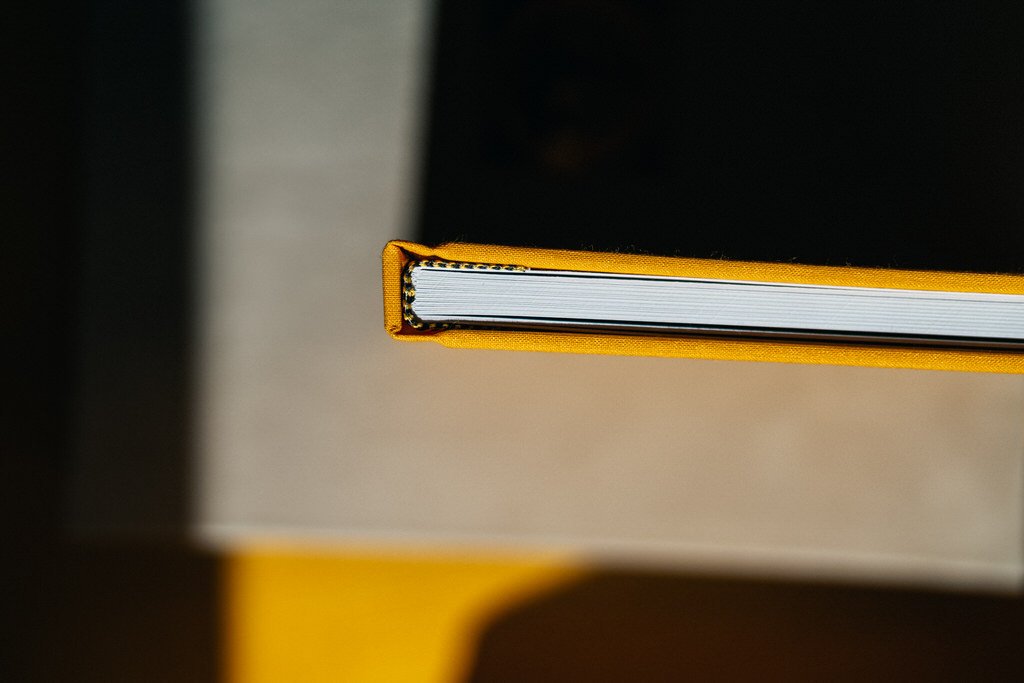 Overhead view of the spine of a closed book with a yellow cover.