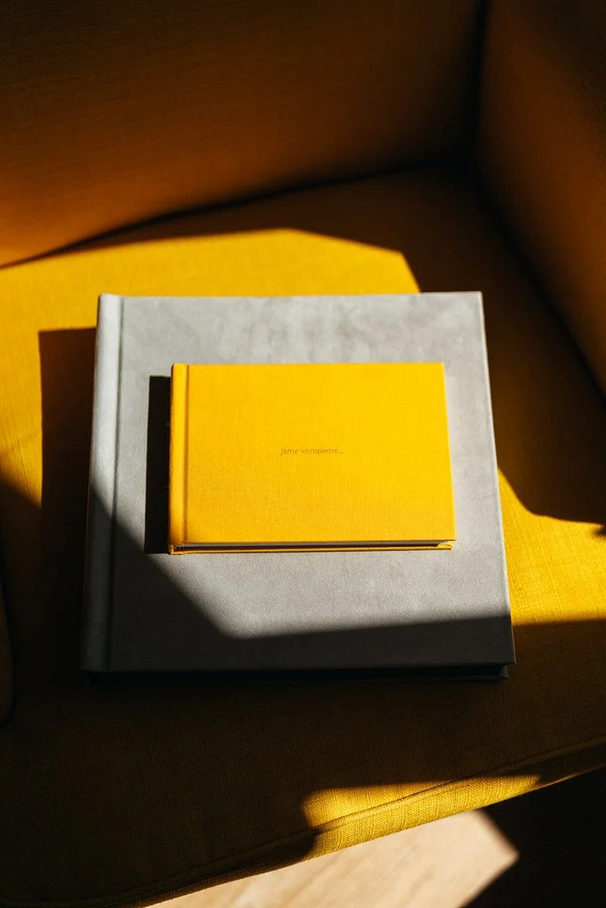 Yellow book on top of larger gray book on yellow chair