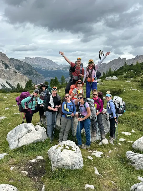 group of hikers in front of dolomites landscape with boulders around